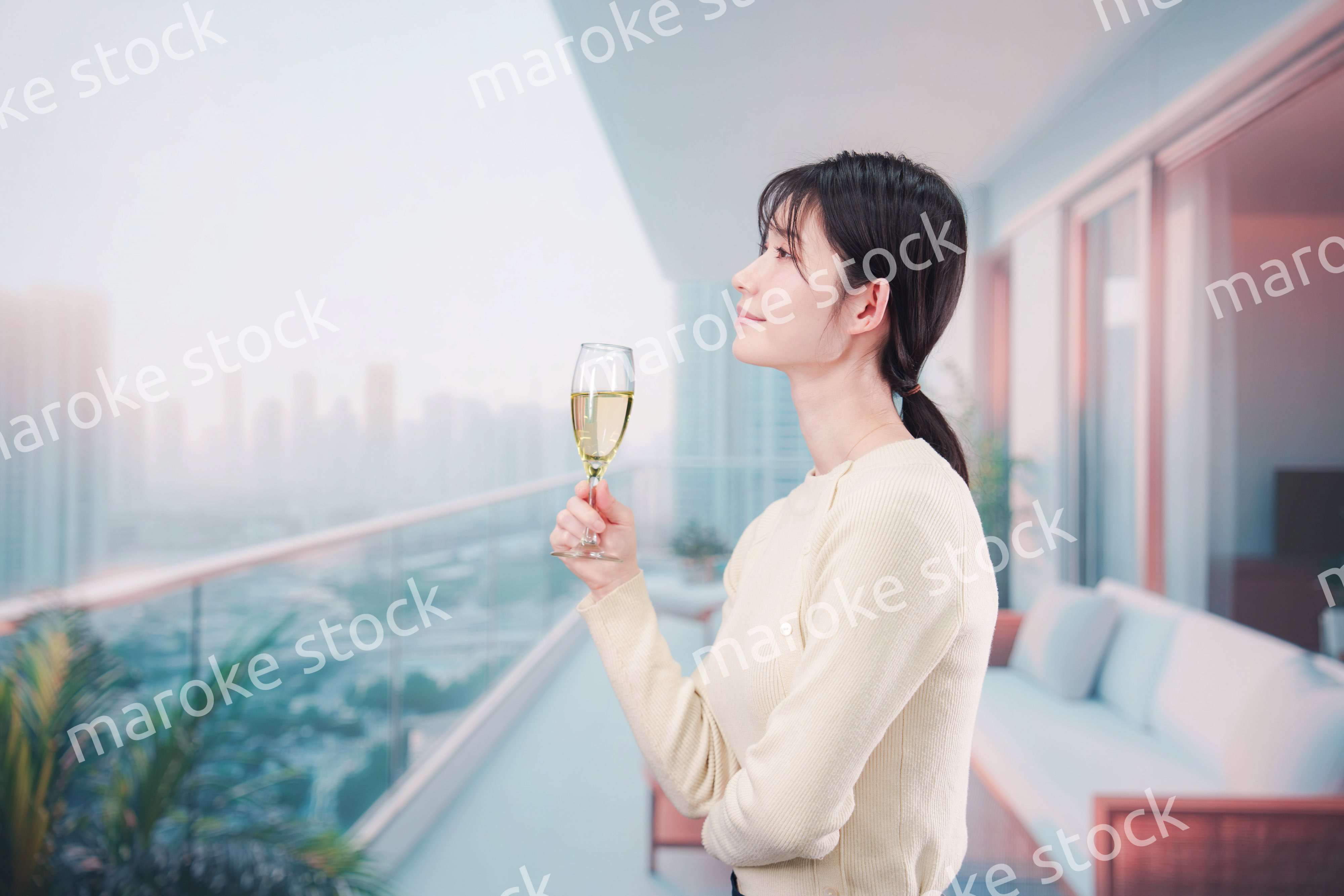 バルコニーでワインを愉しむ若い女性