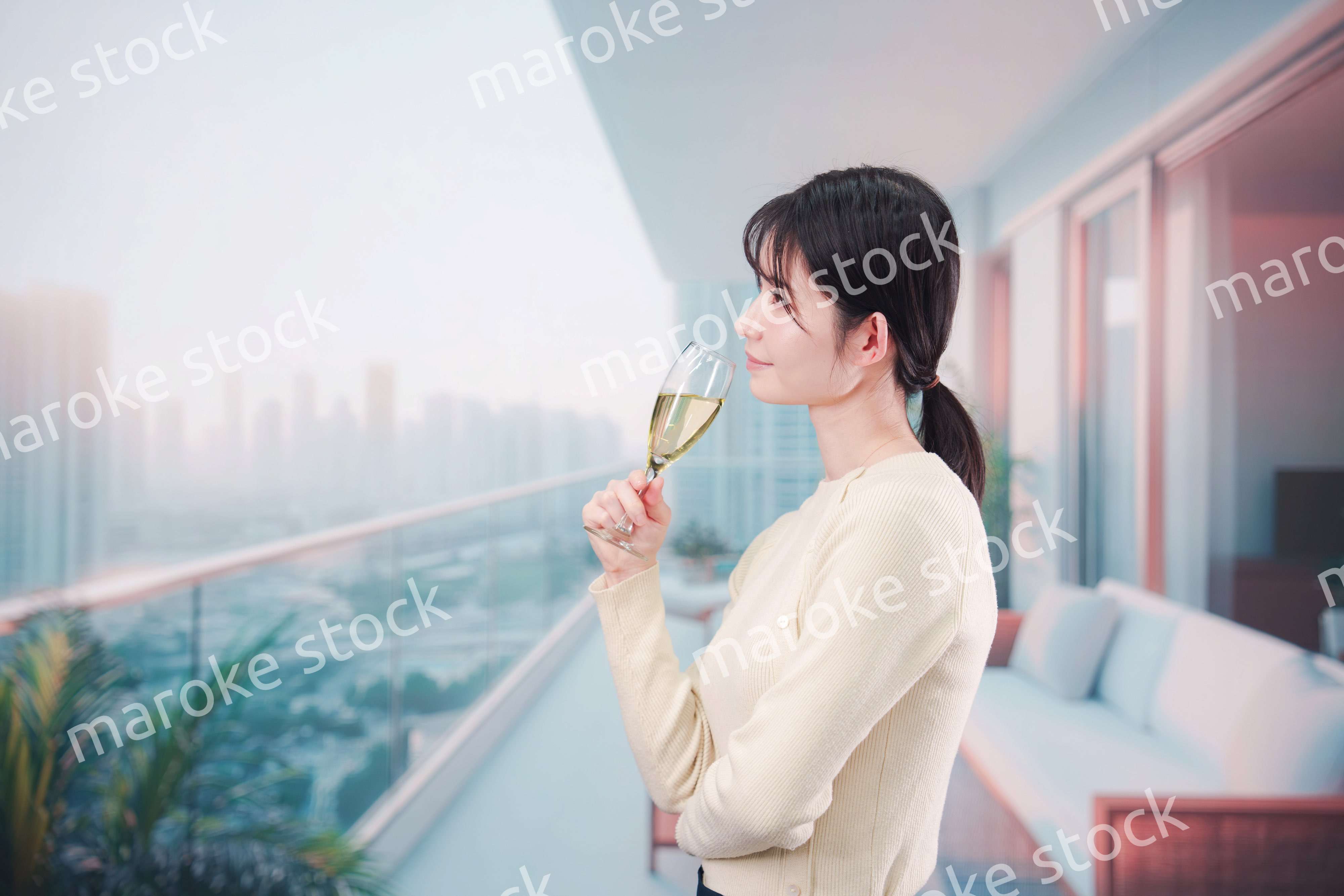 バルコニーでワインを愉しむ若い女性
