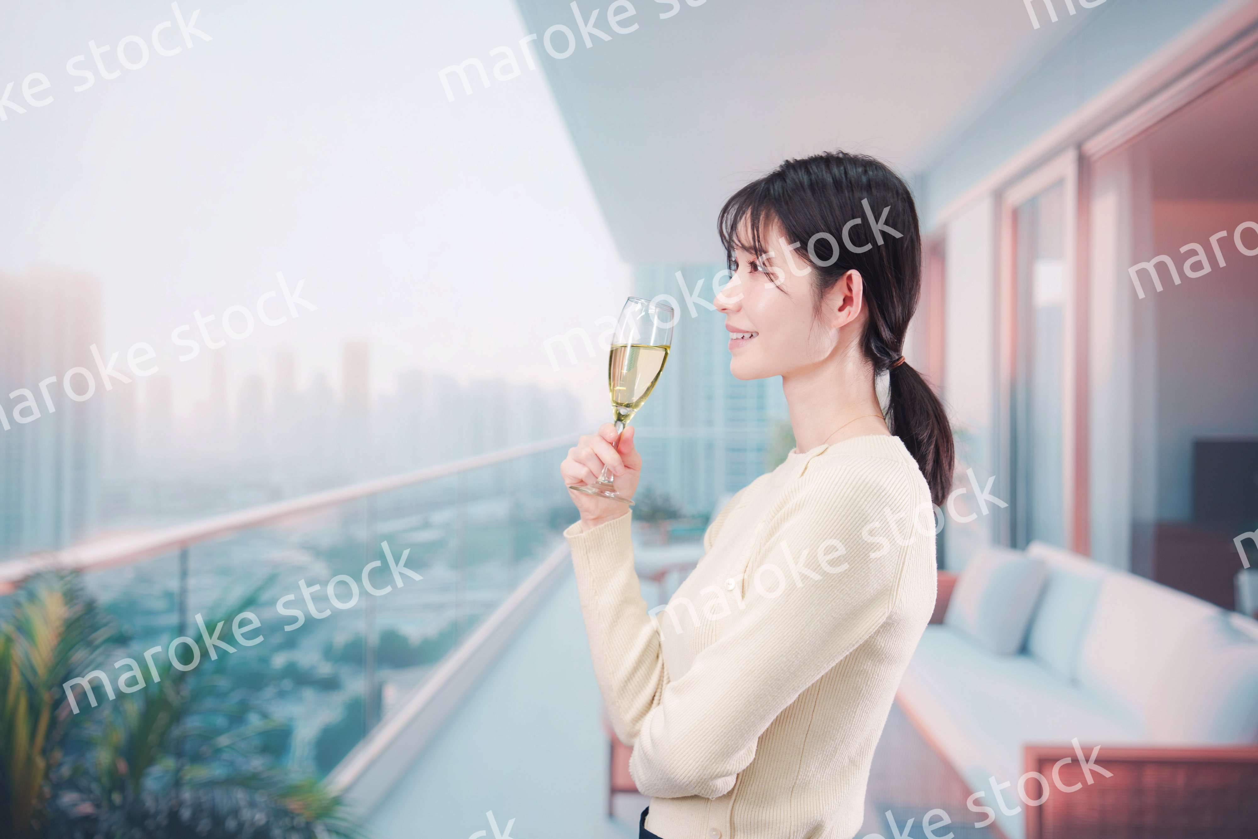 バルコニーでワインを愉しむ若い女性