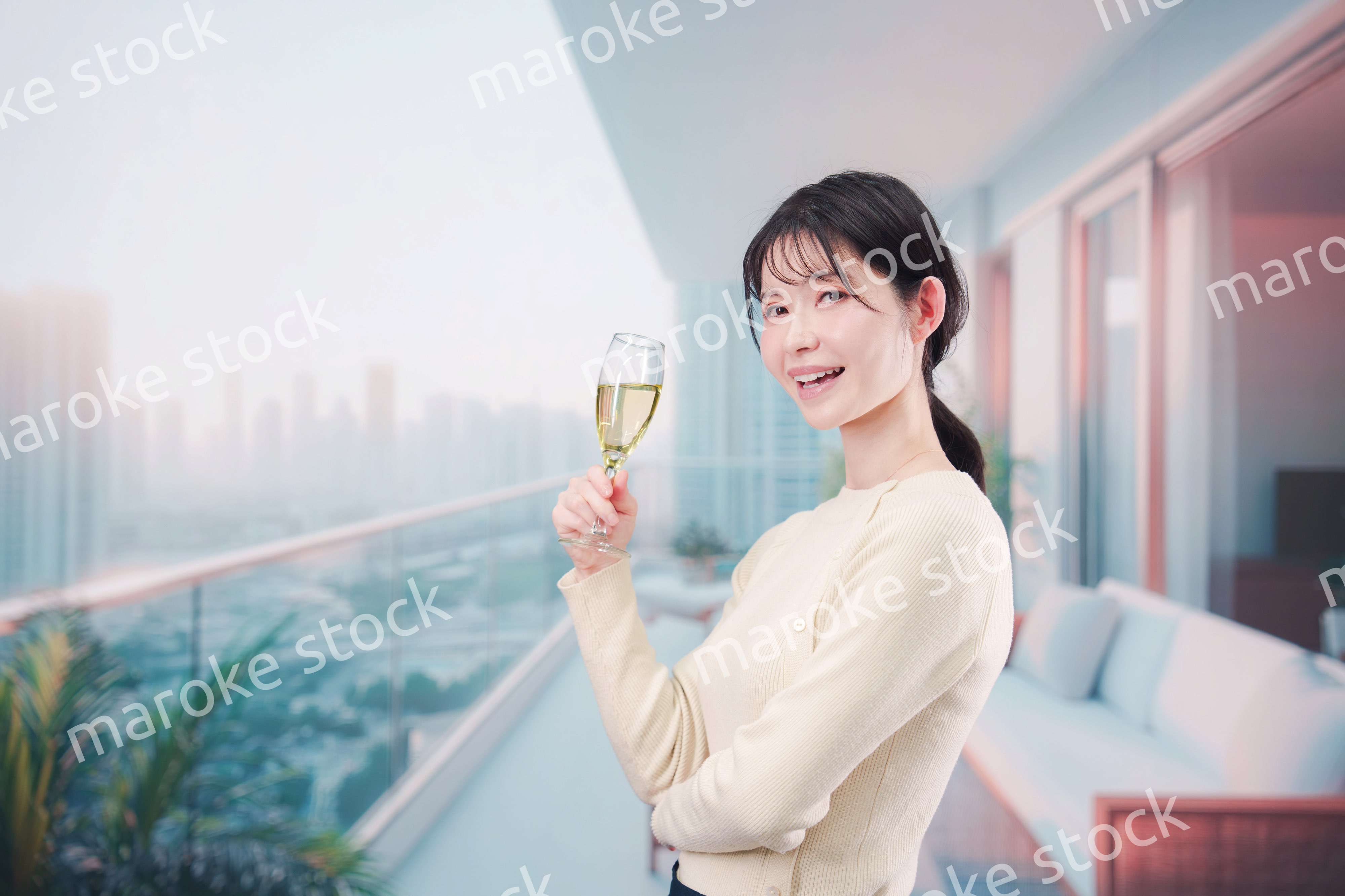 バルコニーでワインを愉しむ若い女性