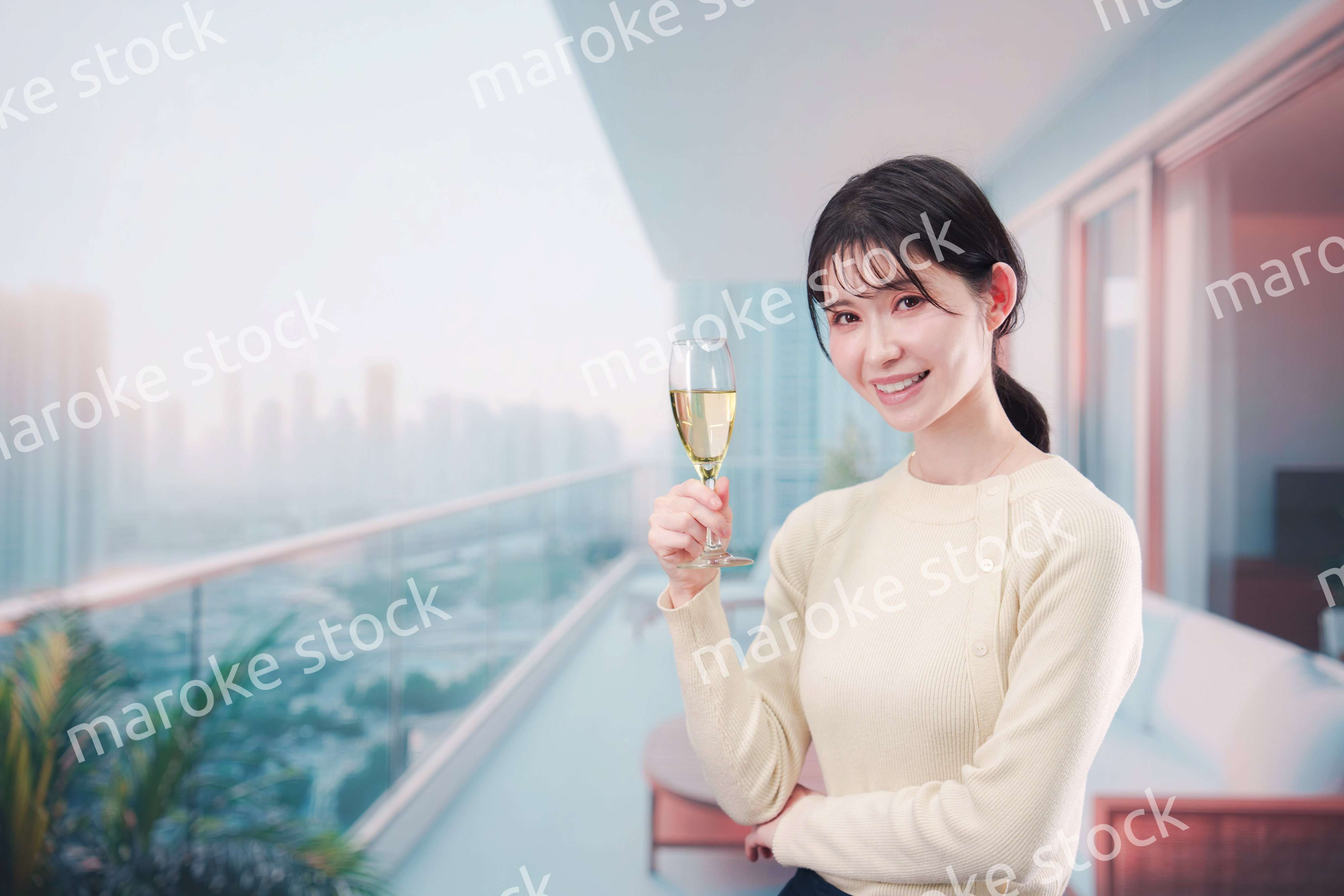 バルコニーでワインを愉しむ若い女性