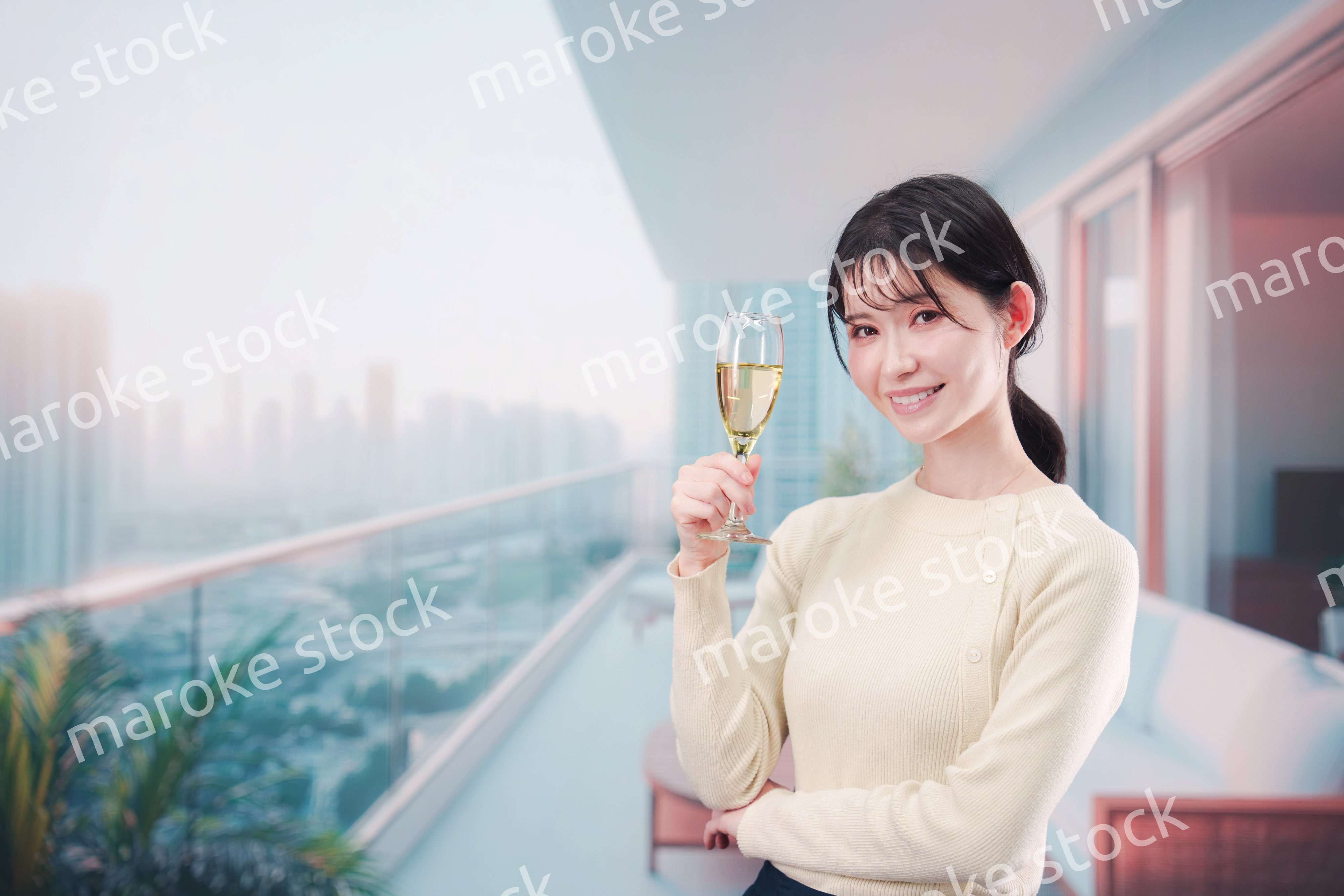 バルコニーでワインを愉しむ若い女性