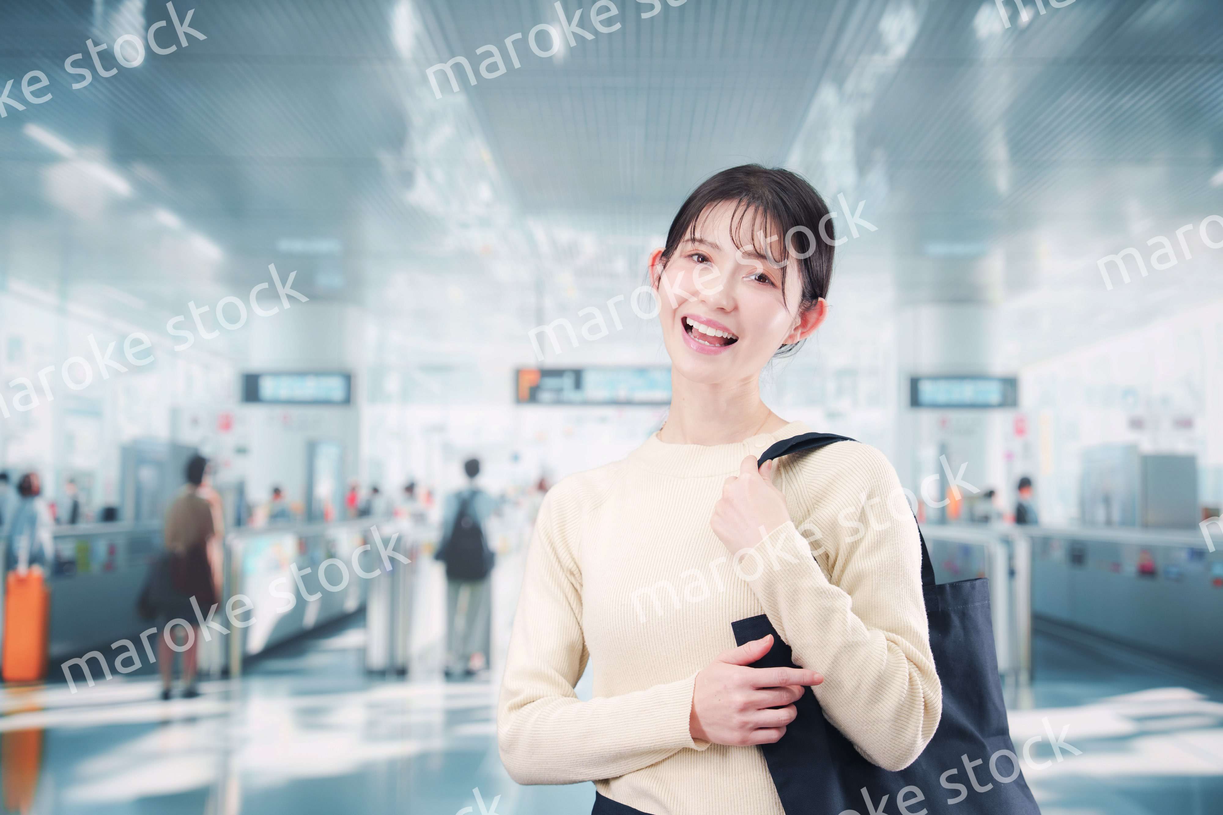 駅で笑顔で待ち合わせをする若い女性