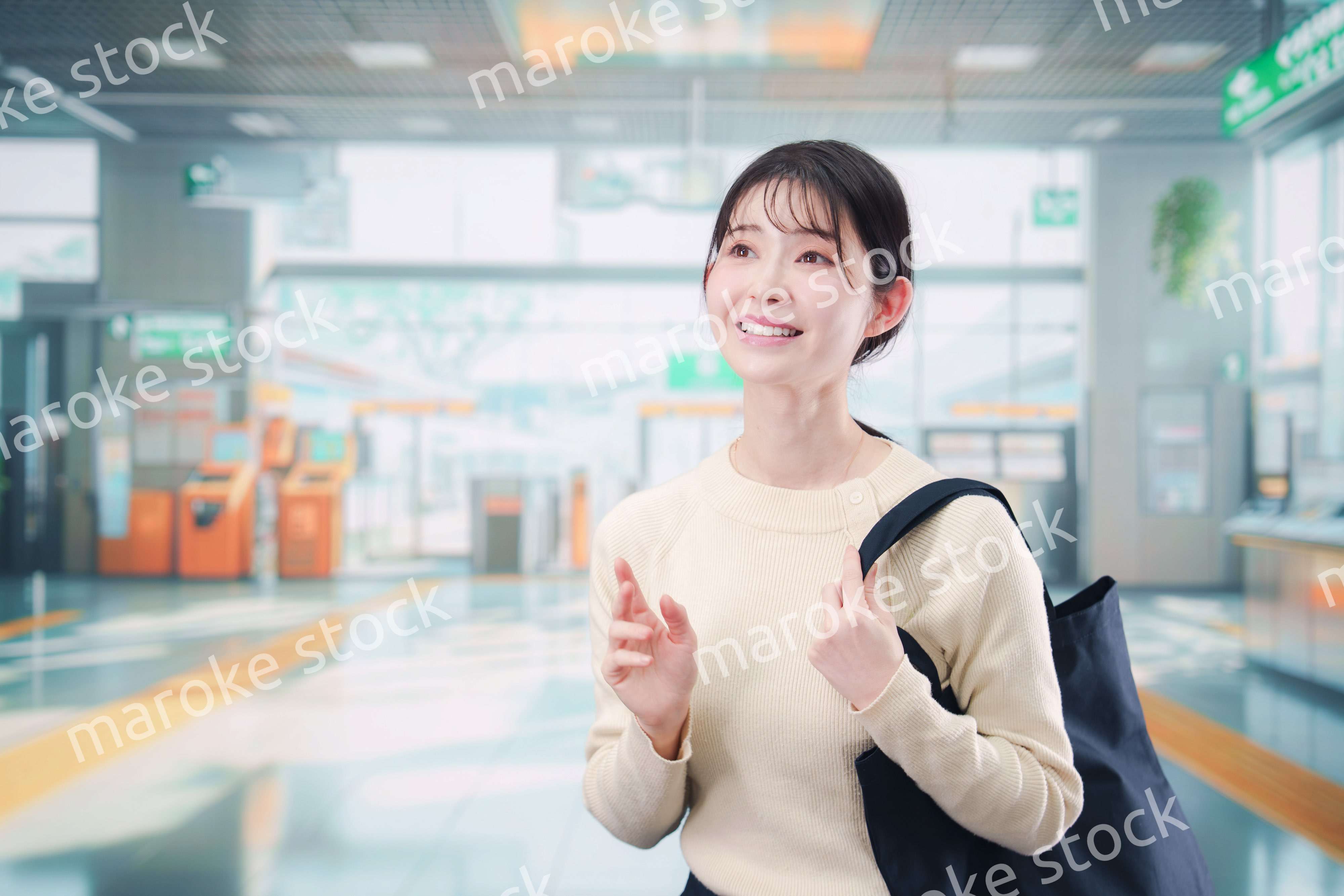 駅で笑顔で待ち合わせをする若い女性