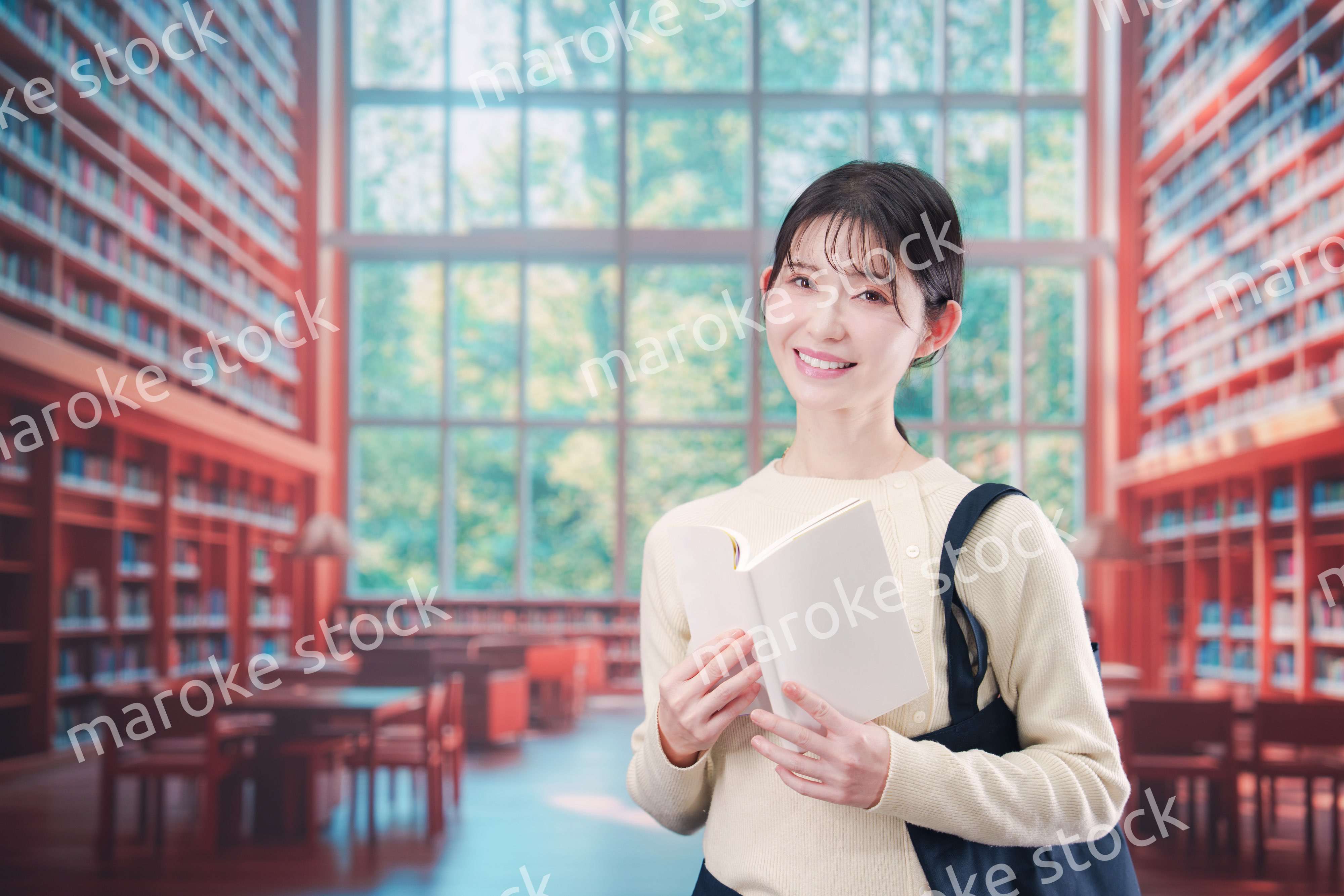 明るい図書館で本を読む若い女性