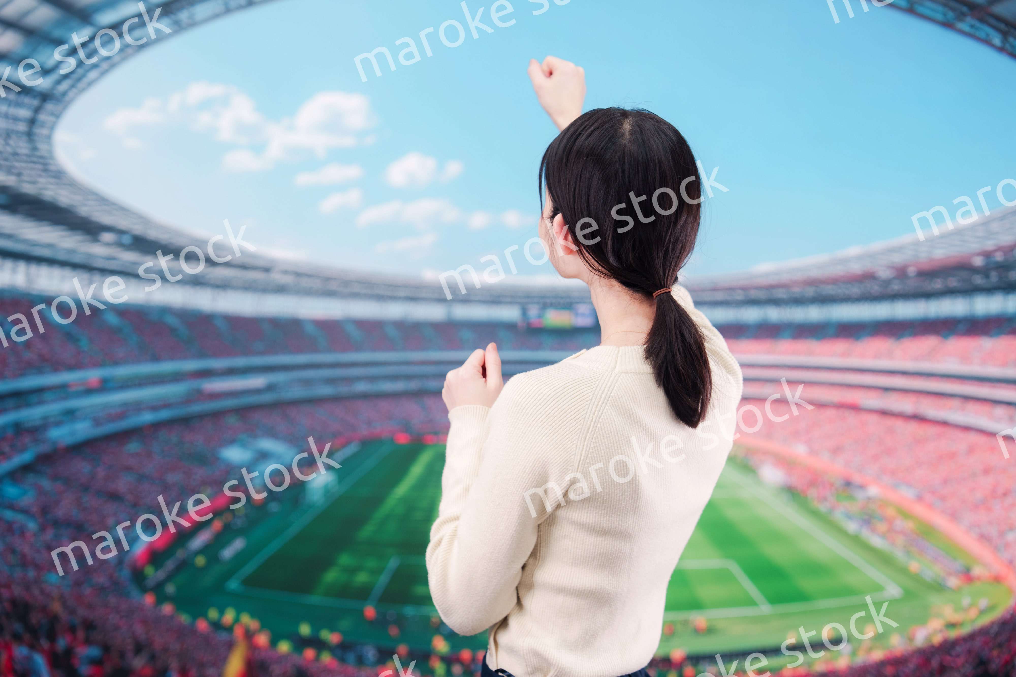 スタジアムで応援をする若い女性