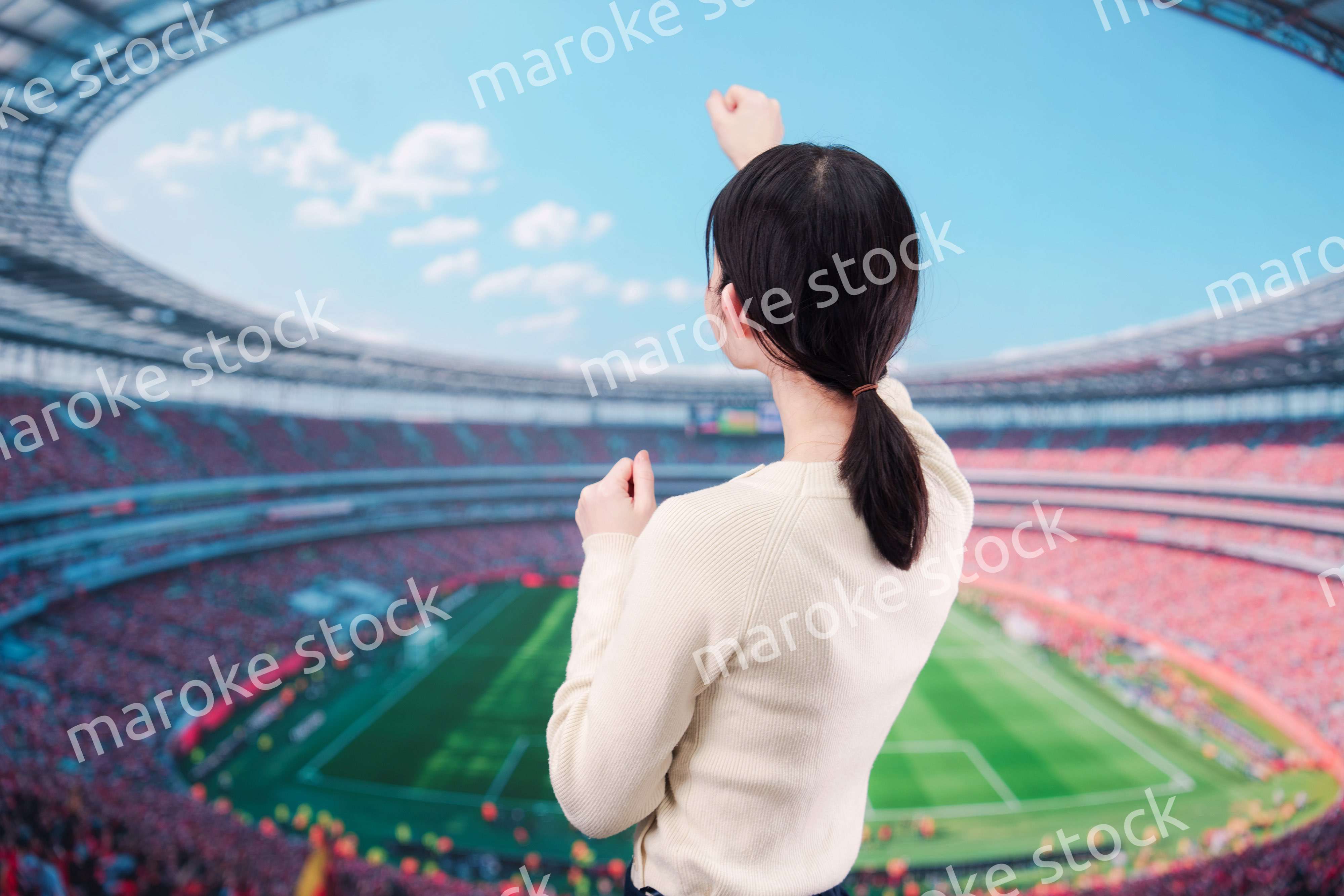 スタジアムで応援をする若い女性