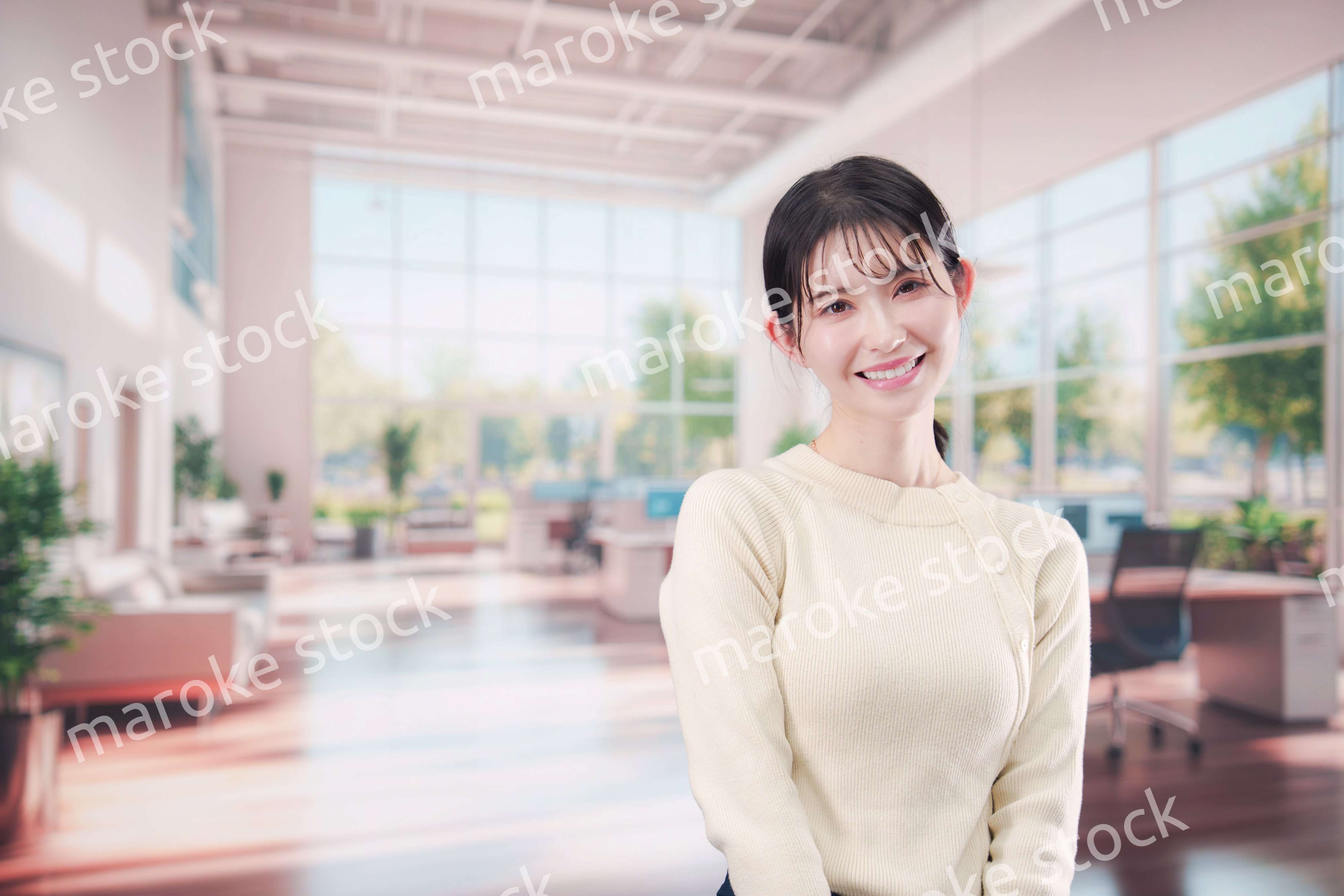 明るいオフィスで働く若い女性スタッフ