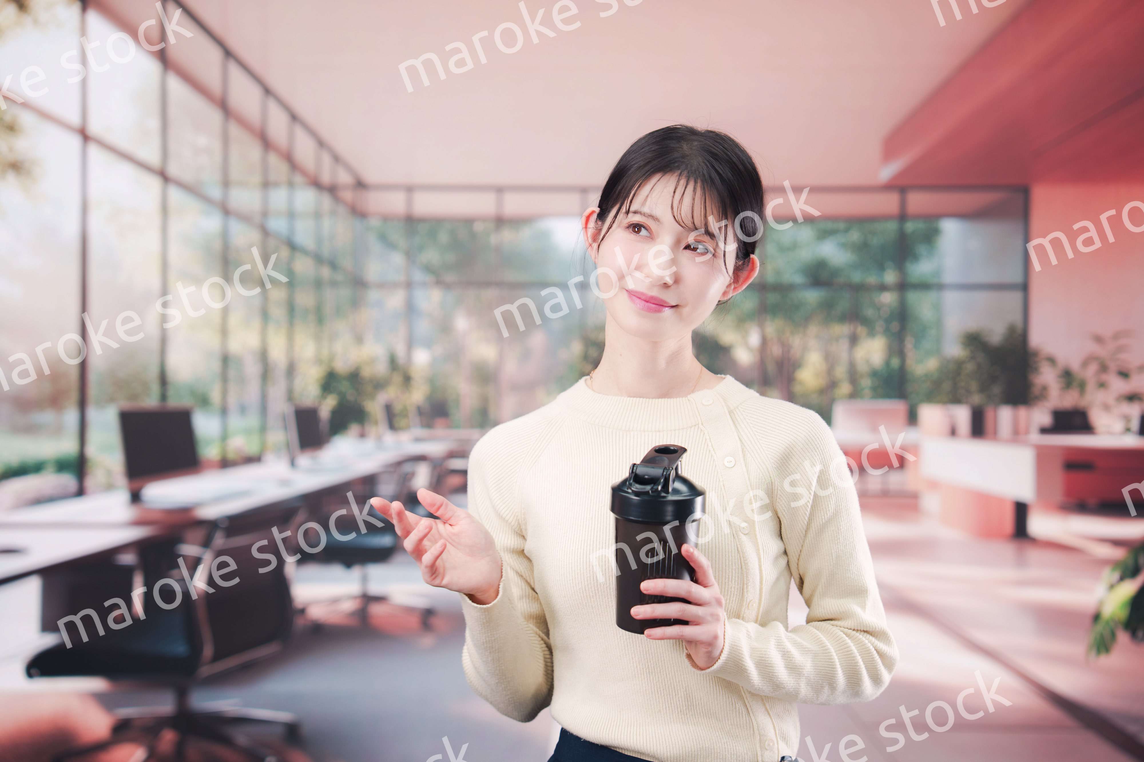 オフィスでマイボトルを持ち歩く若い女性