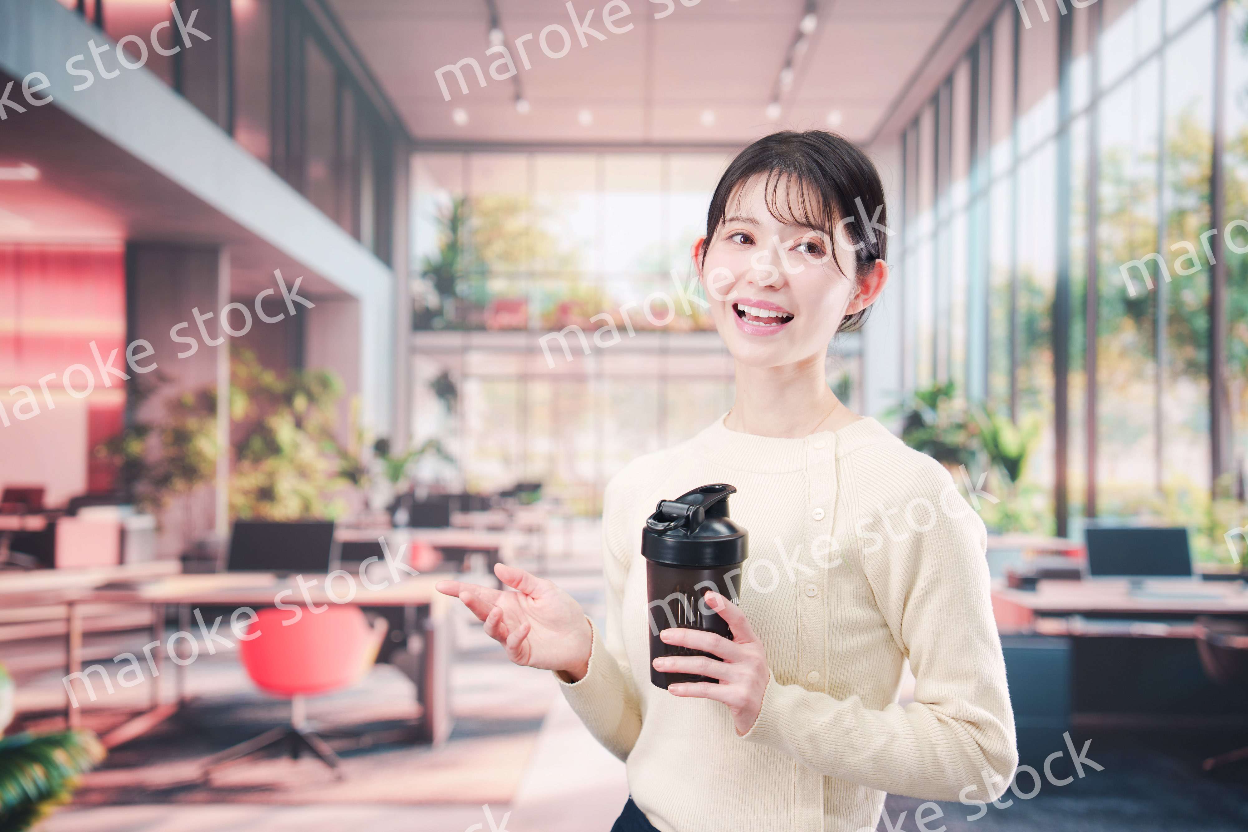 オフィスでマイボトルを持ち歩く若い女性