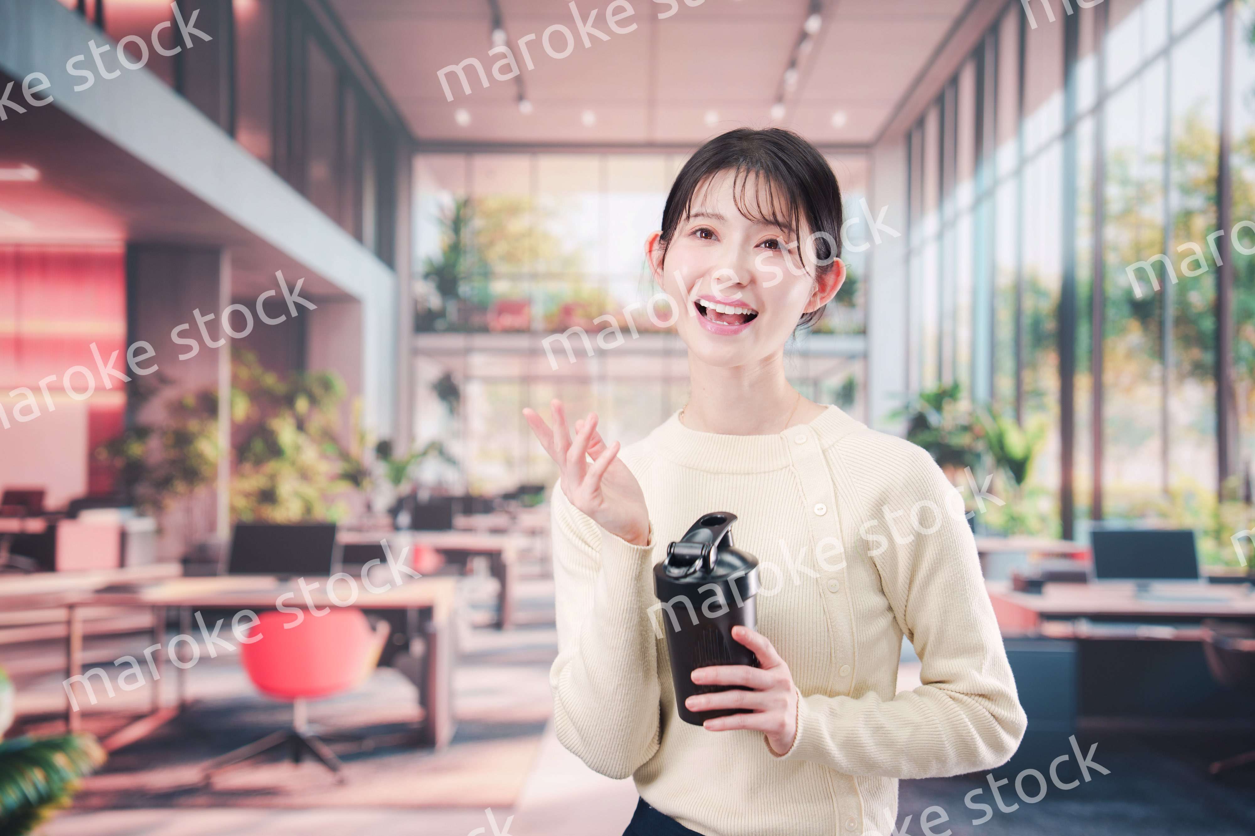 オフィスでマイボトルを持ち歩く若い女性