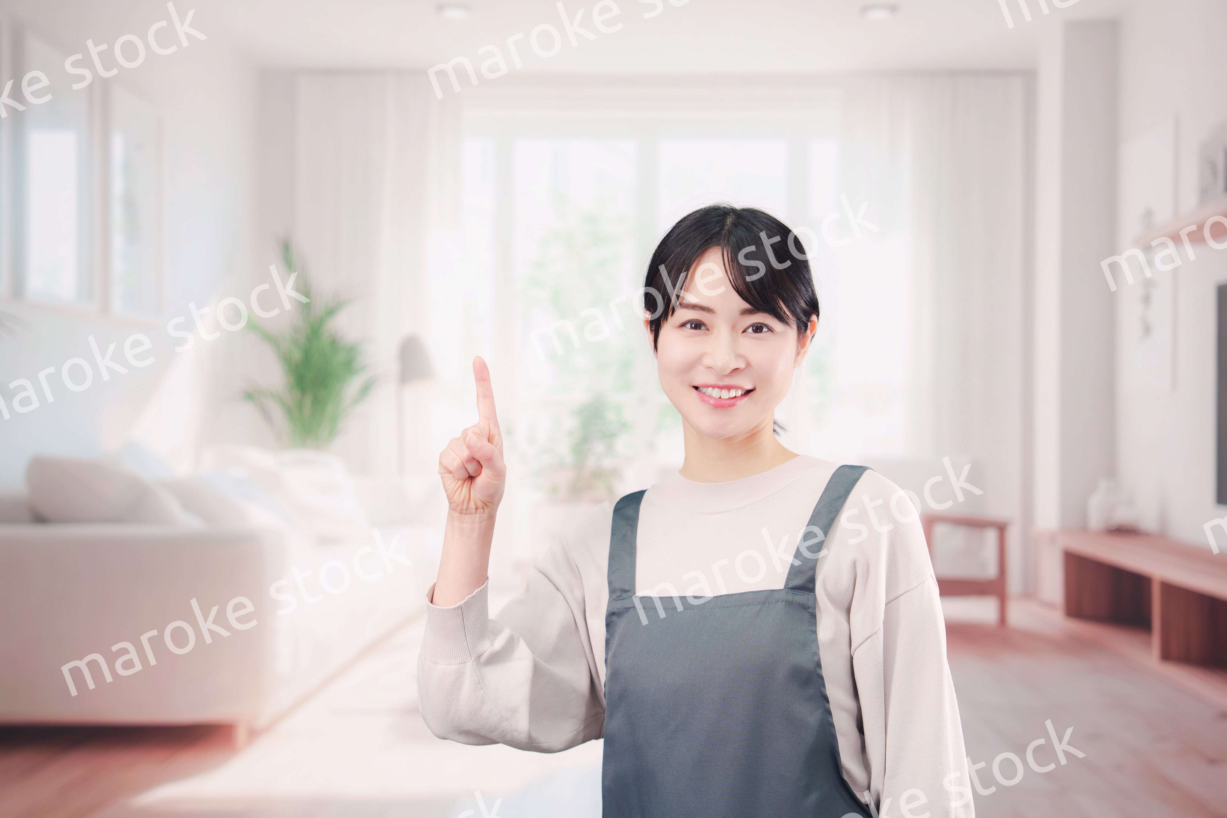 エプロンをしてお客様の家で働く家事代行の女性