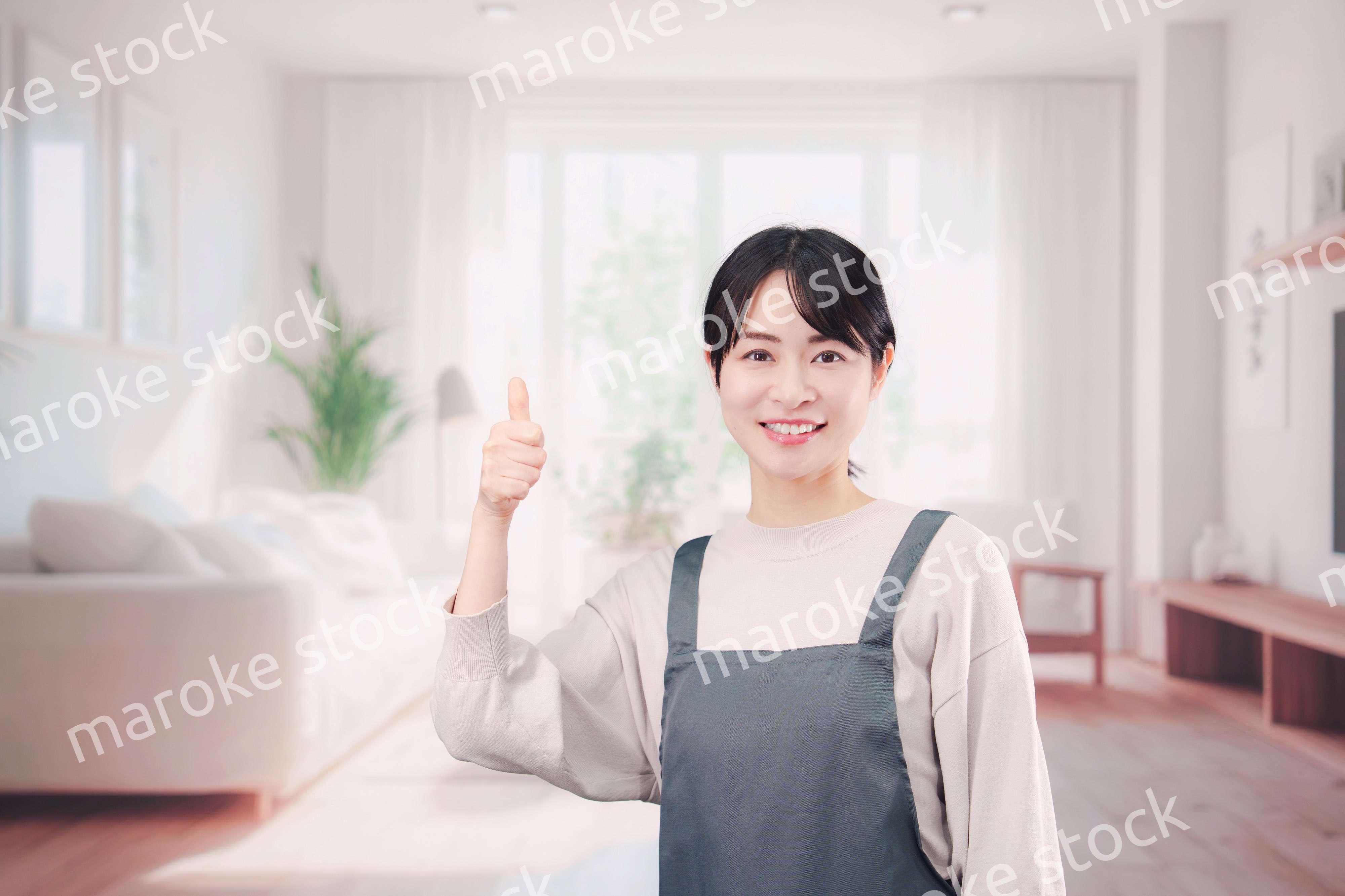 エプロンをしてお客様の家で働く家事代行の女性