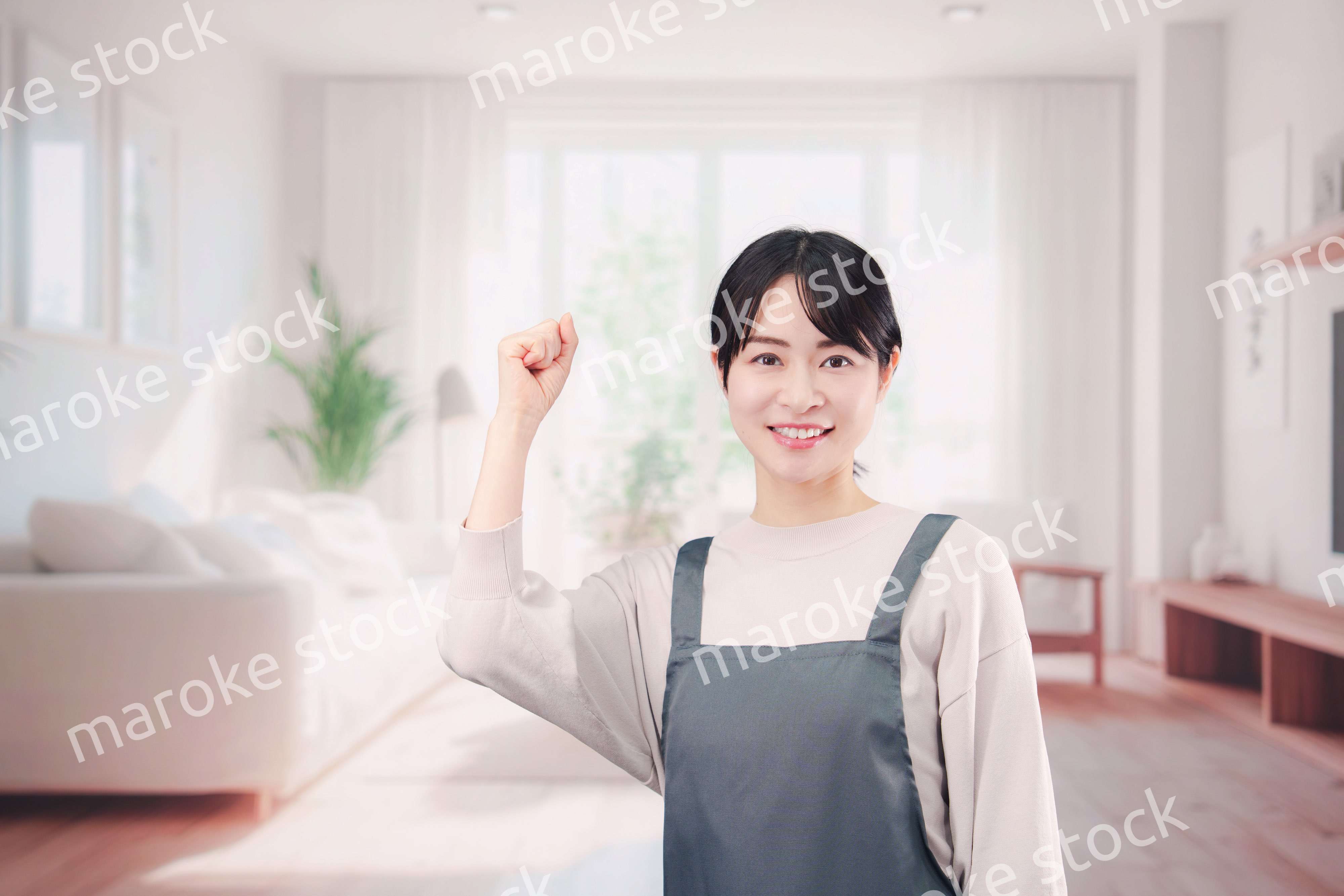 エプロンをしてお客様の家で働く家事代行の女性