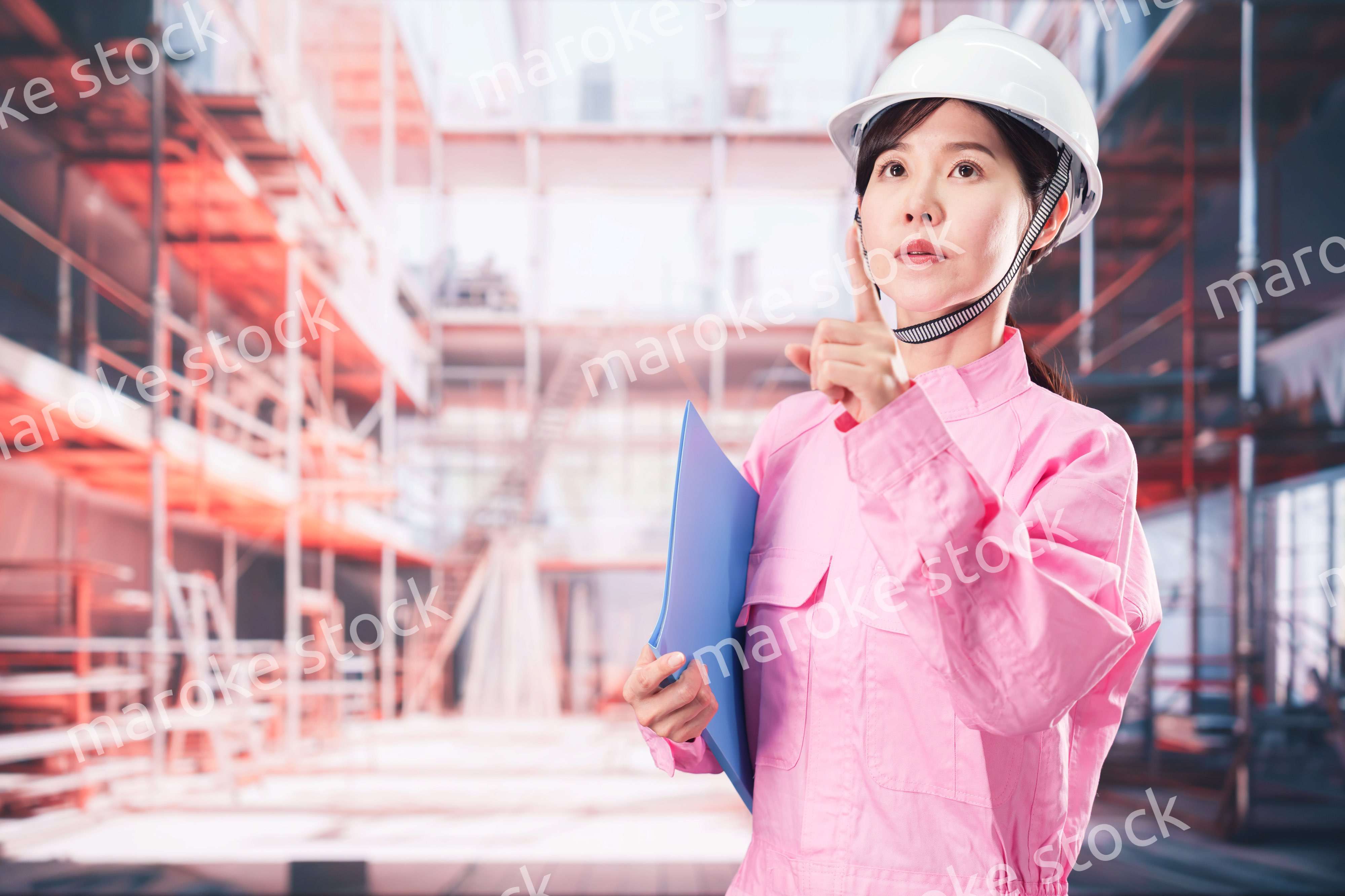 建設現場で確認をする女性の作業員