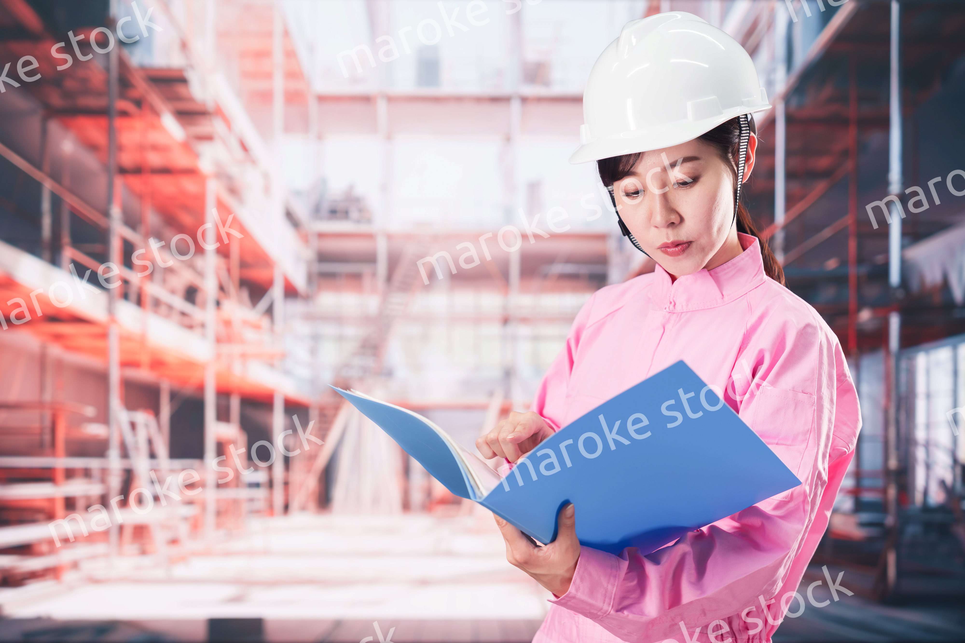 建設現場で確認をする女性の作業員