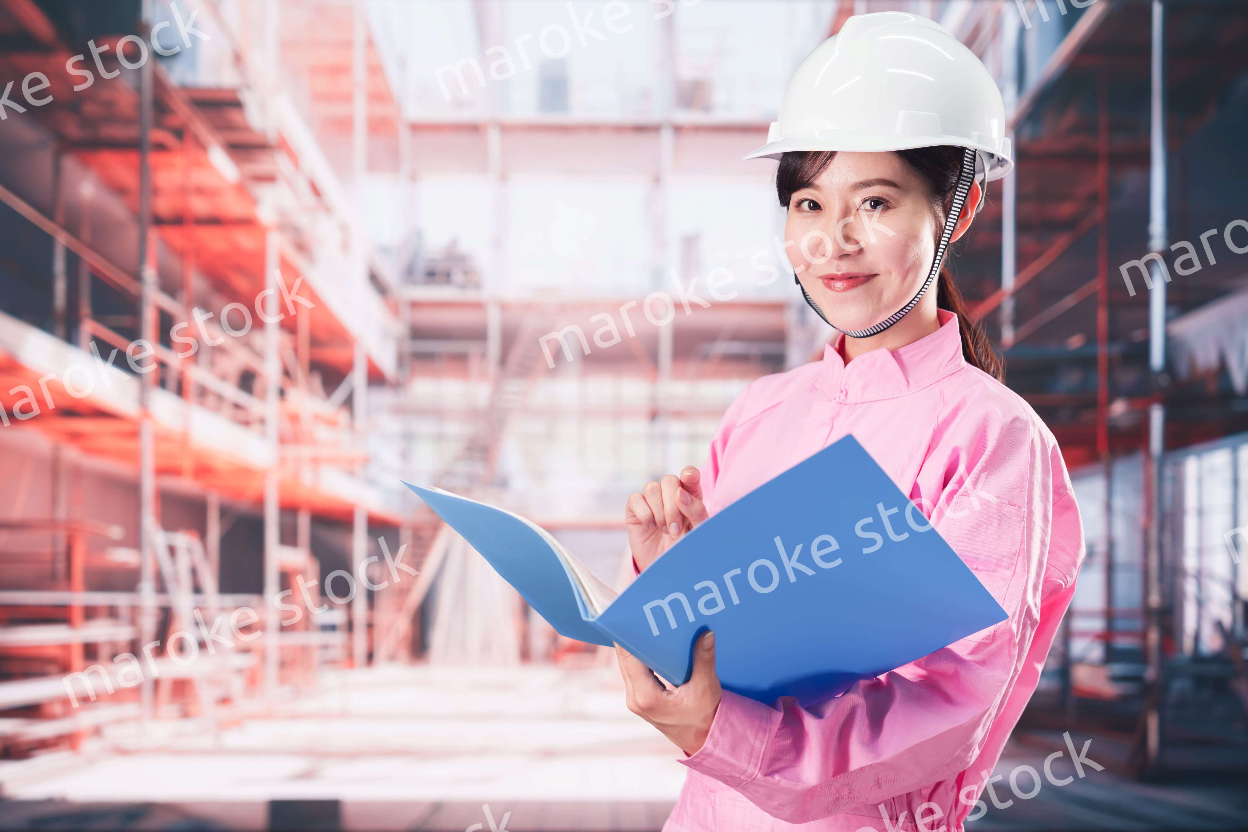 建設現場で確認をする女性の作業員