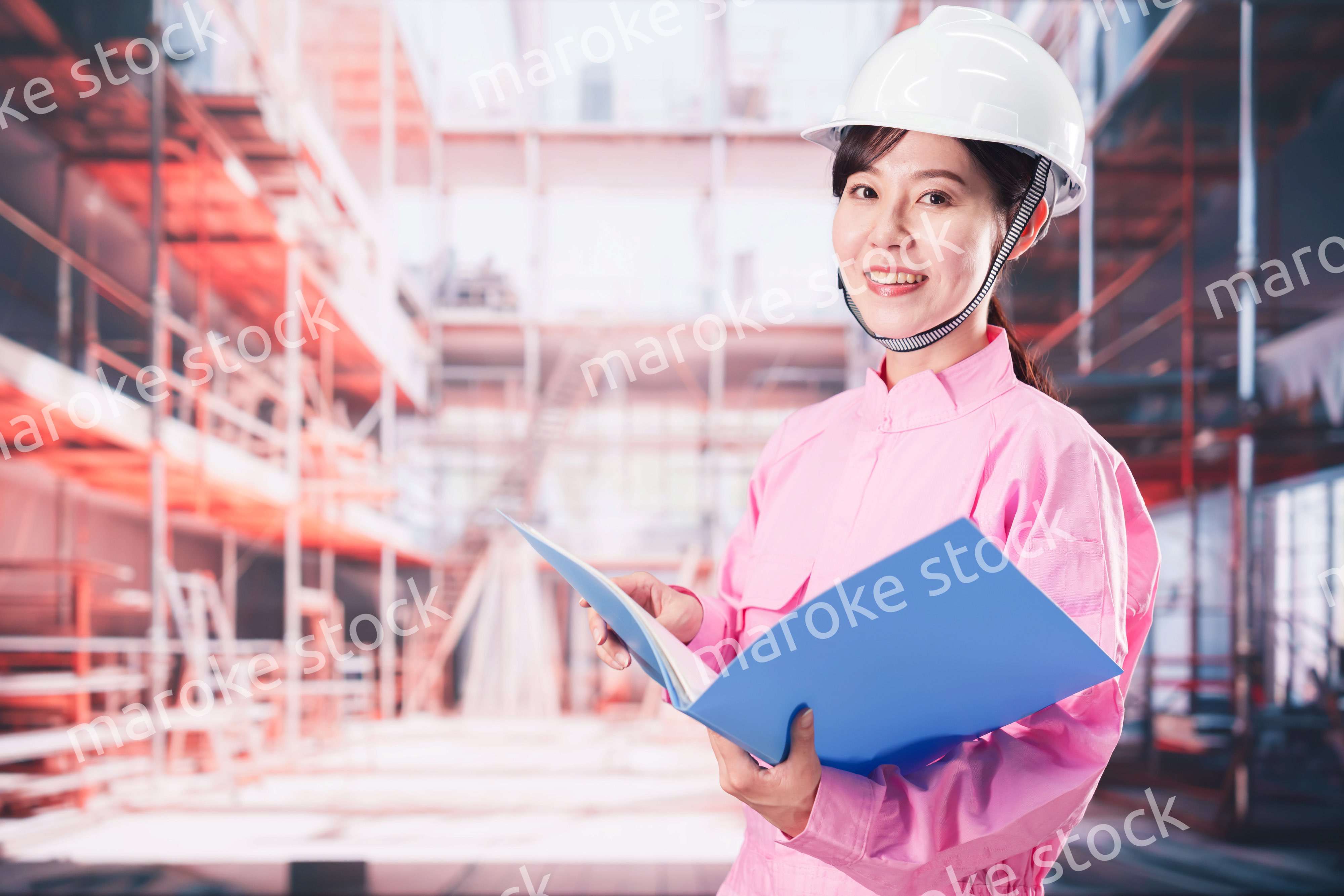 建設現場で確認をする女性の作業員