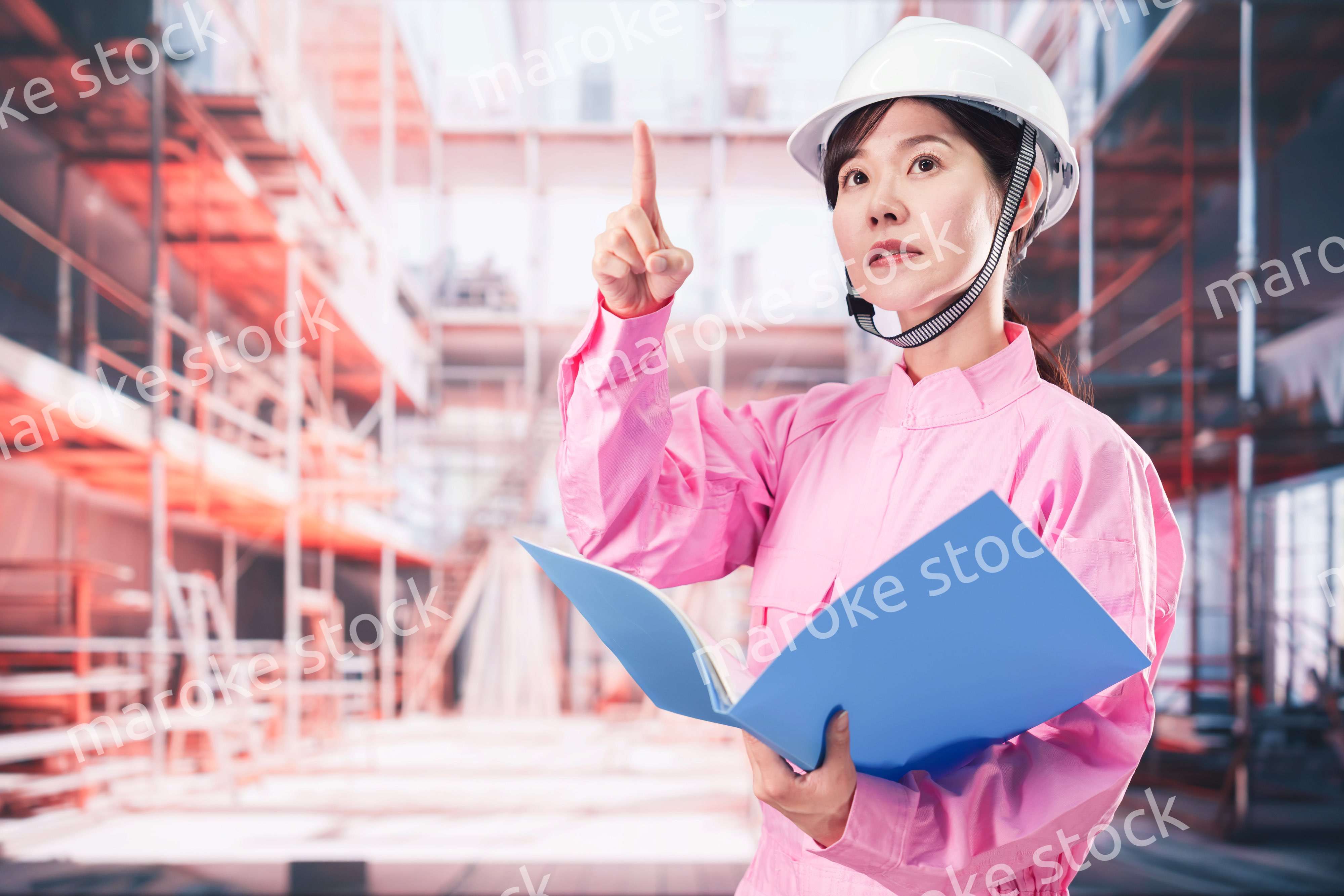 建設現場で確認をする女性の作業員