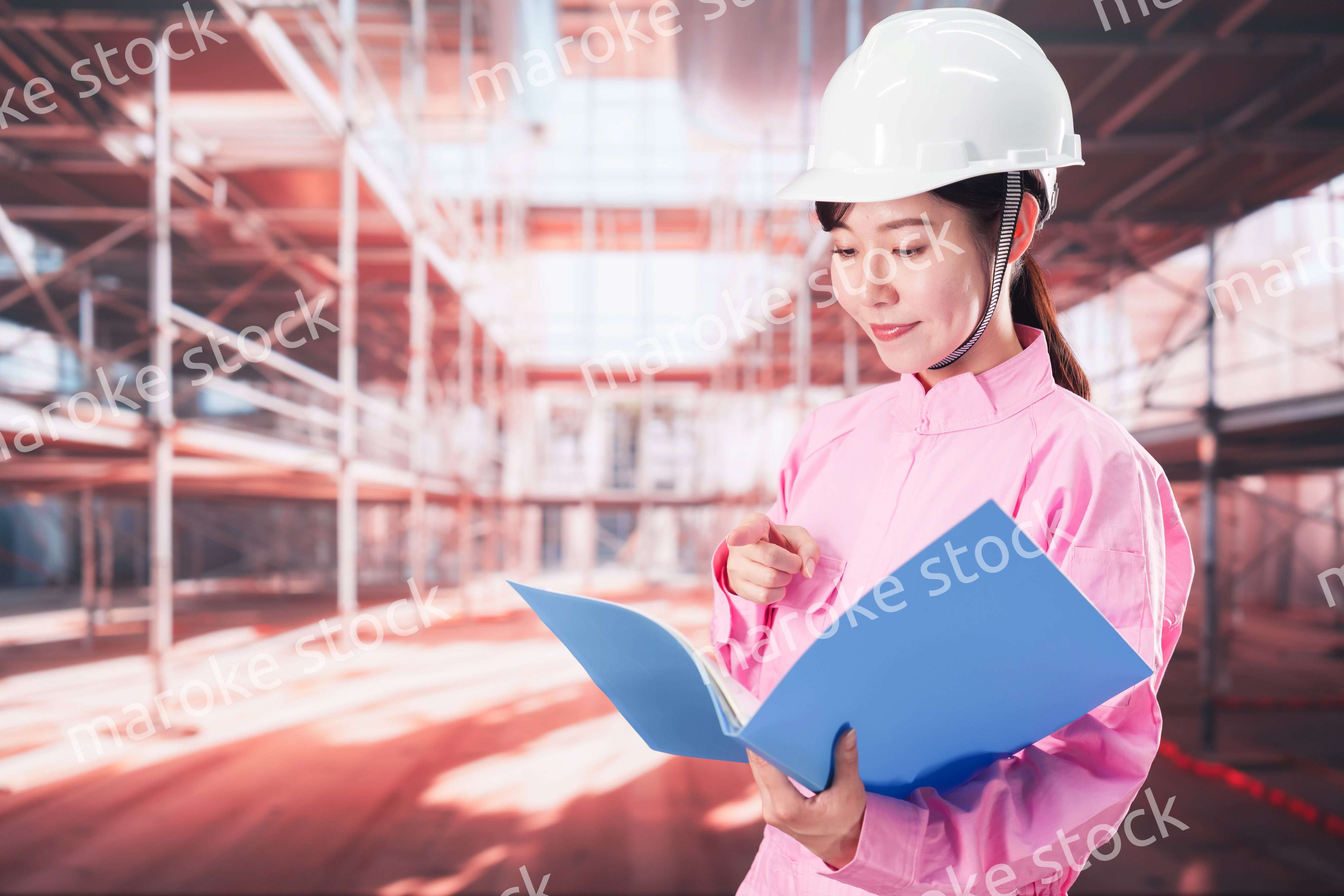 建設現場で確認をする女性の作業員