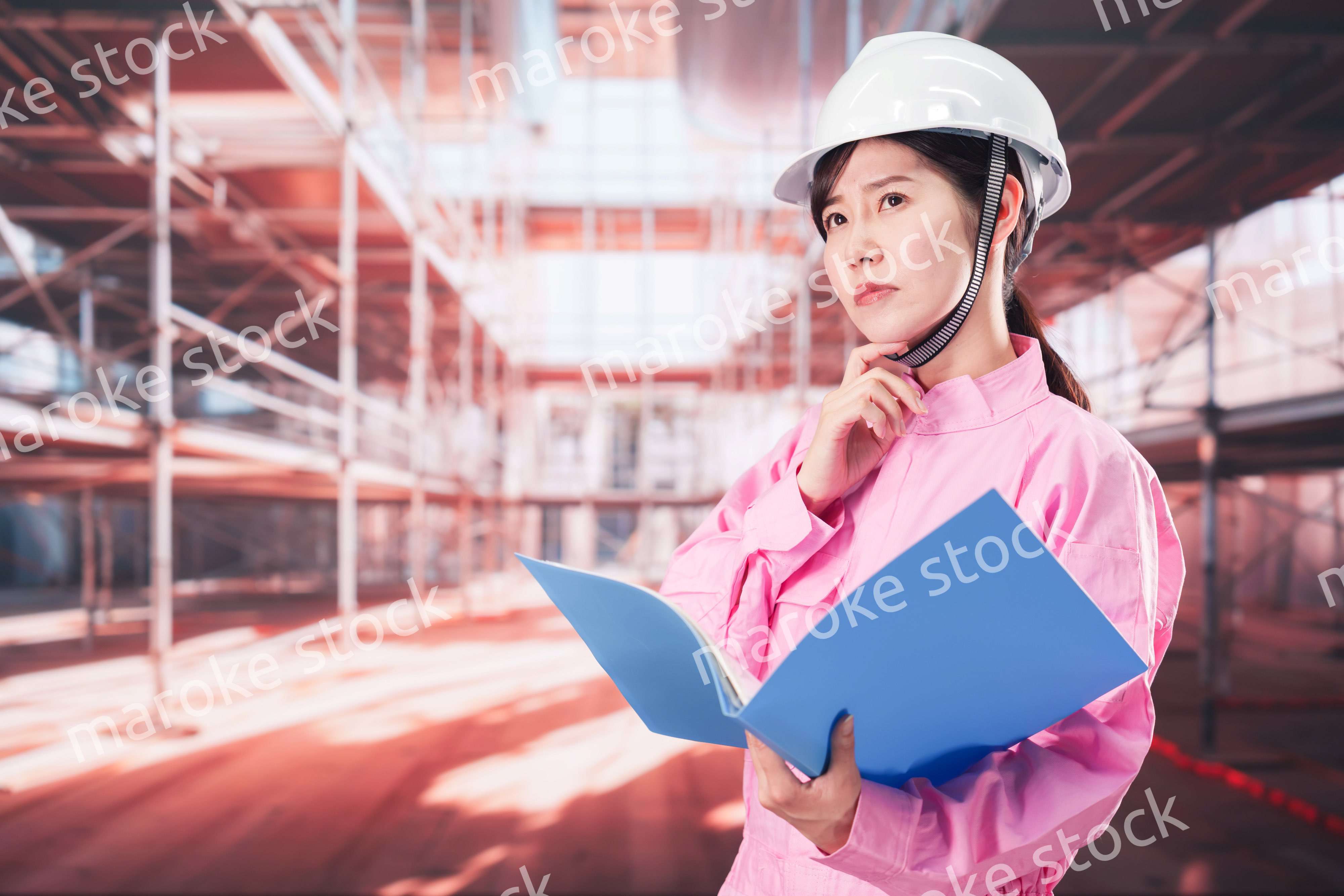 建設現場で確認をする女性の作業員