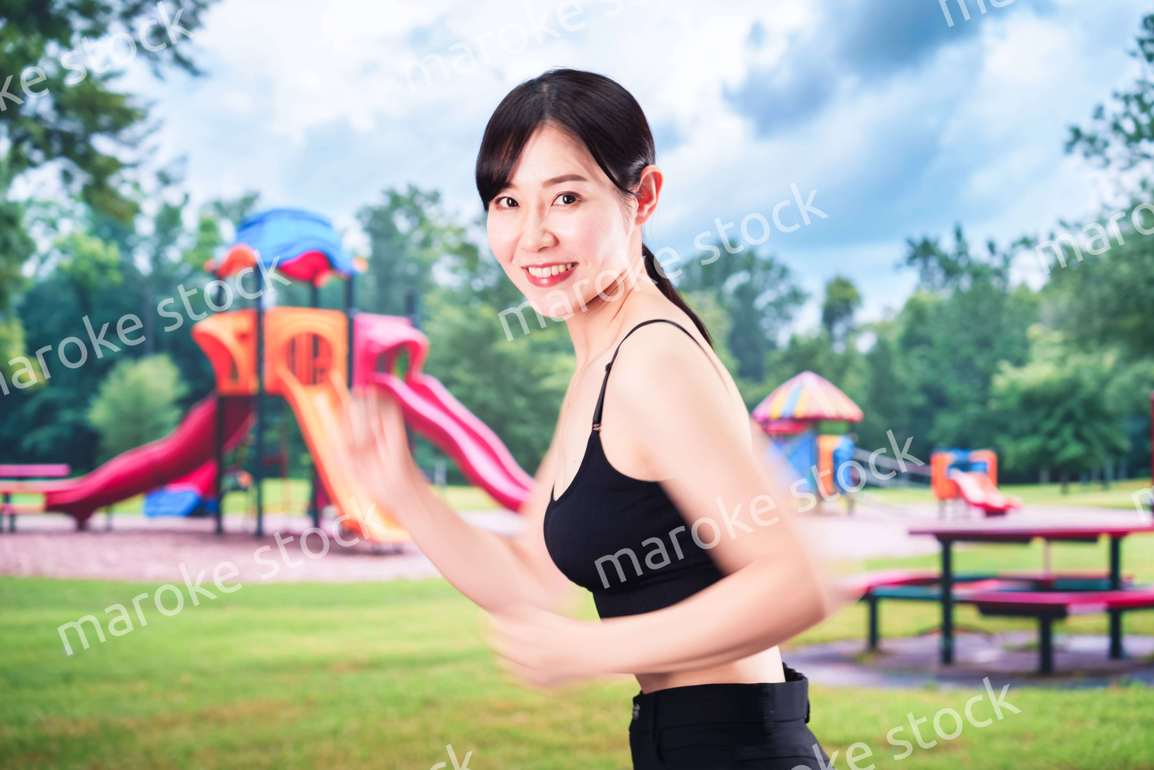 公園でランニングをする若い女性