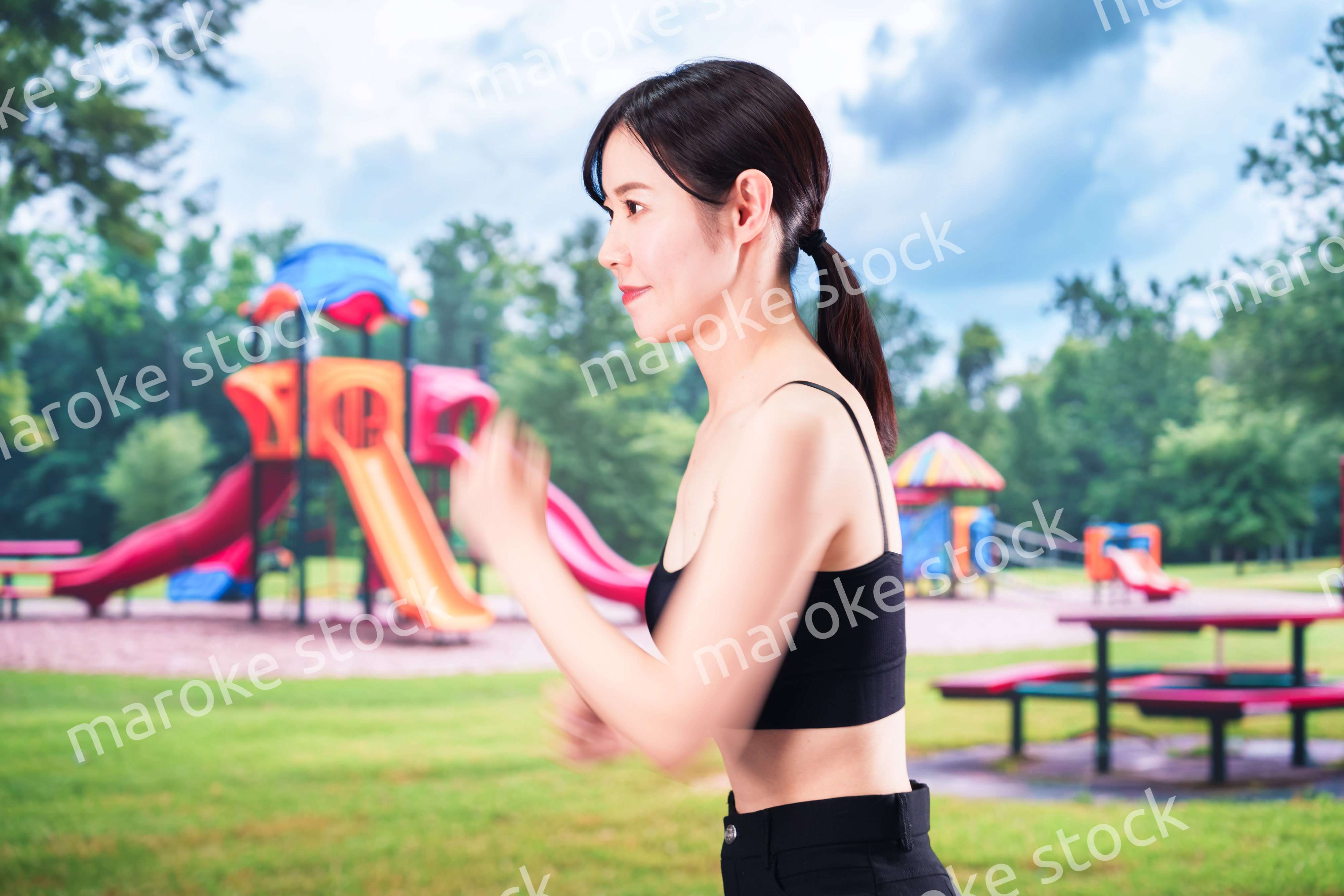 公園でランニングをする若い女性