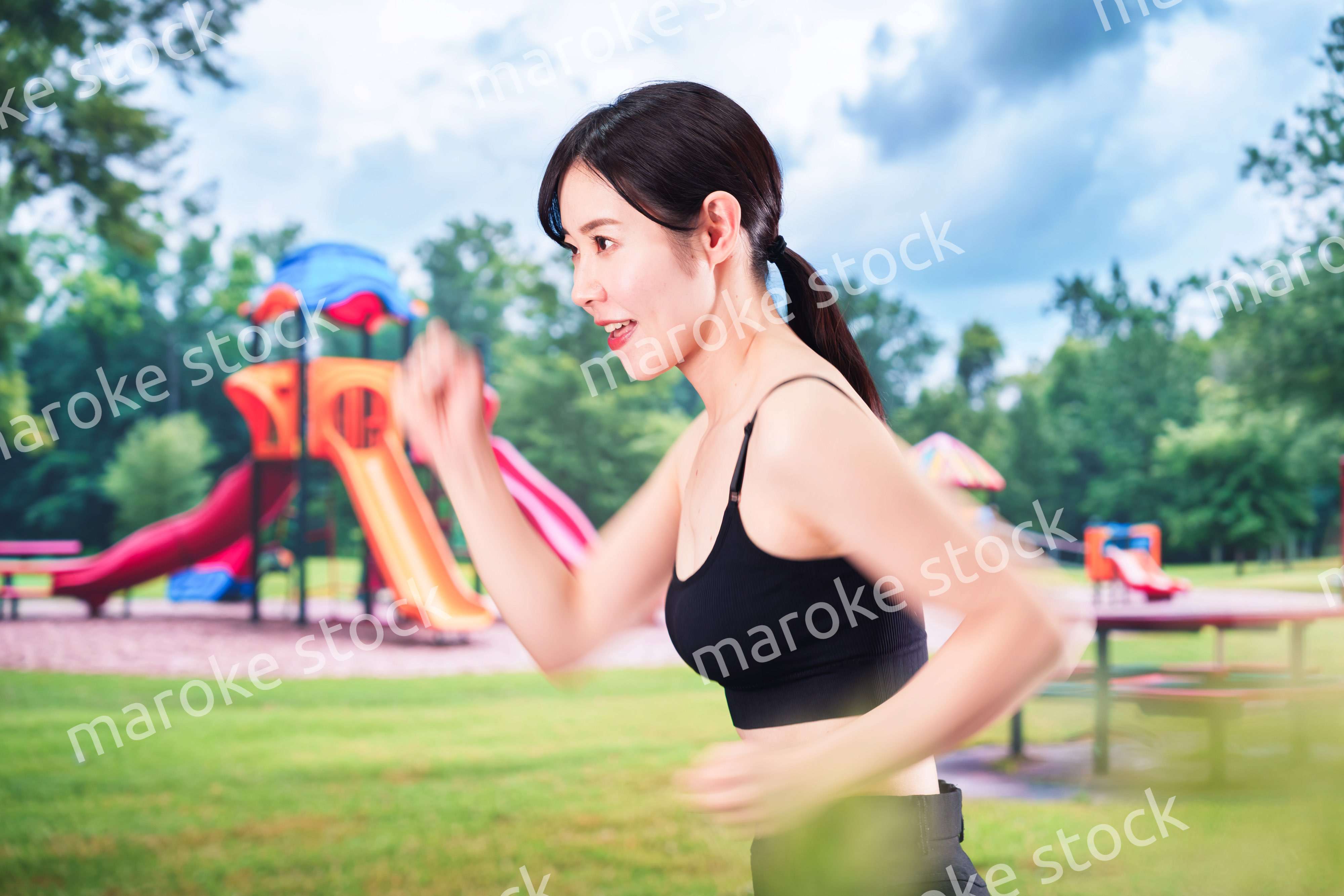 公園でランニングをする若い女性