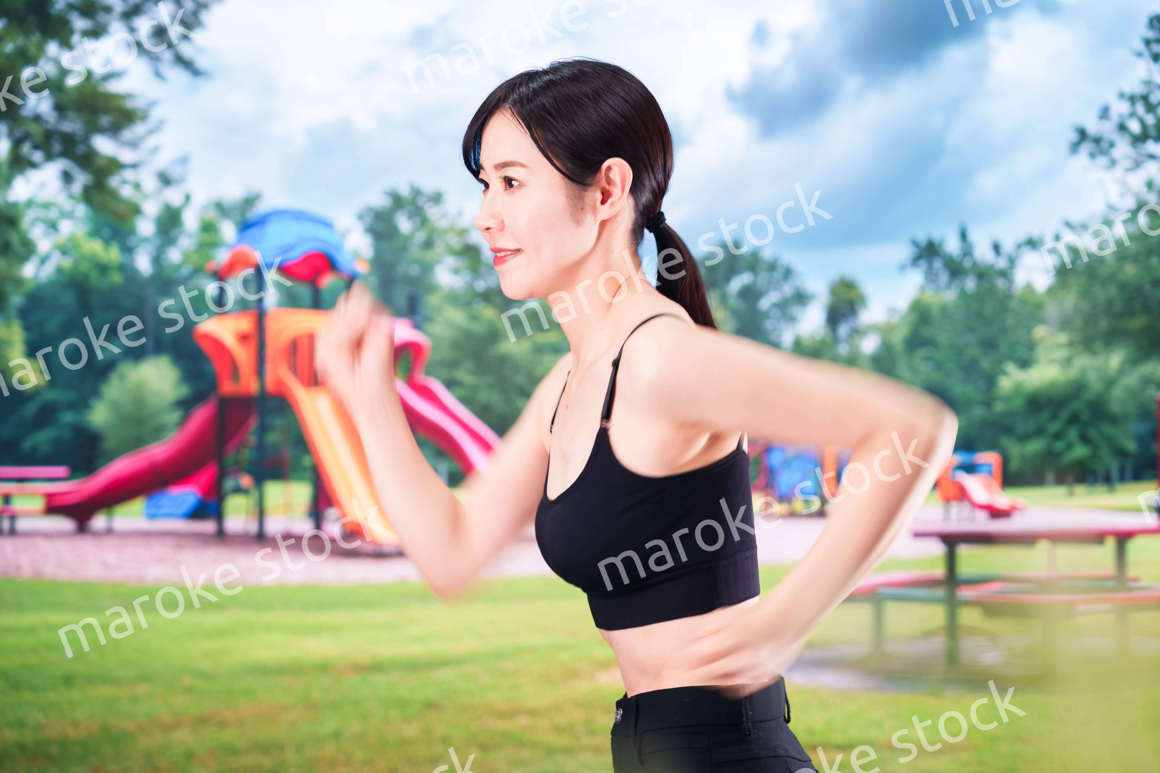 公園でランニングをする若い女性