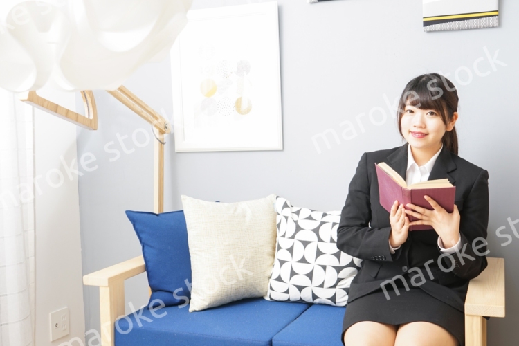 スーツを着て読書をする女性