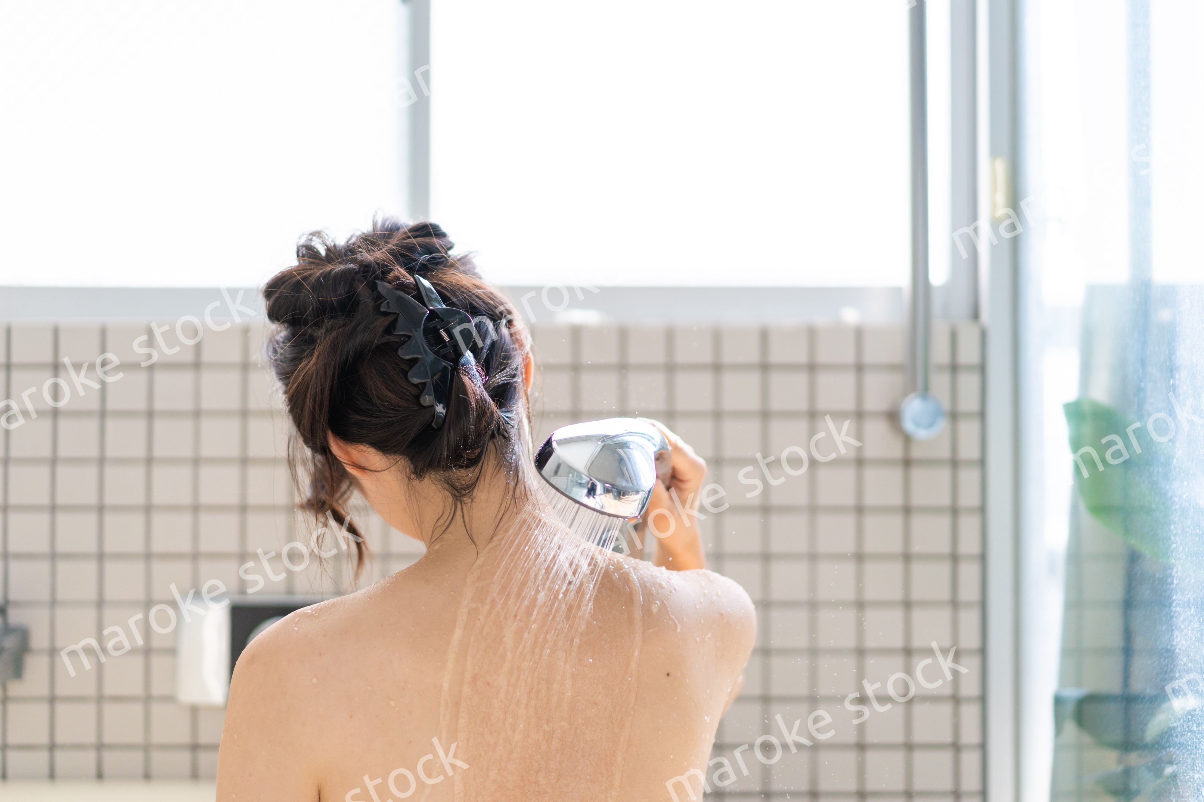 お風呂でシャワーを浴びる若い女性 Maroke Stock｜写真素材をフォトグラファーから直接購入できるストックフォトサイト