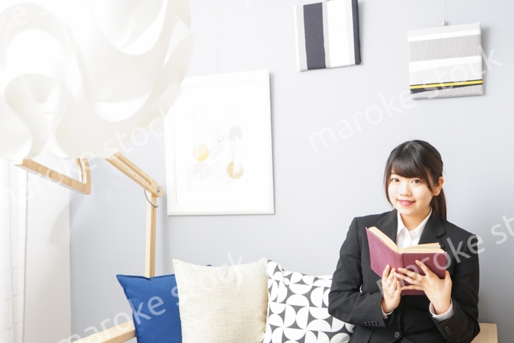 スーツを着て読書をする女性