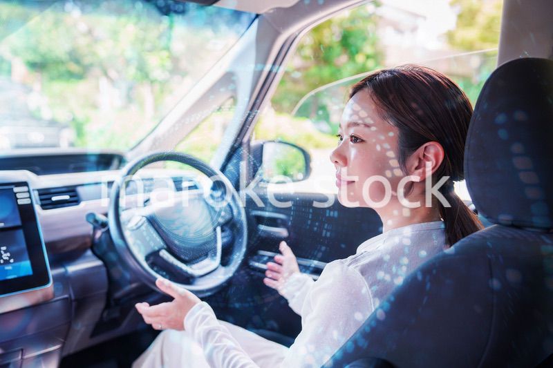 自動運転の車を運転する若い女性