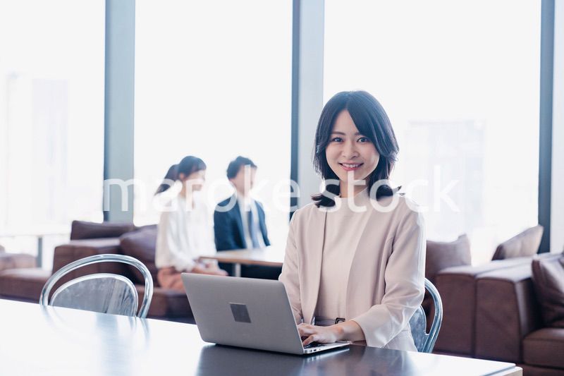 シェアオフィスでノートパソコンを使うビジネスウーマン