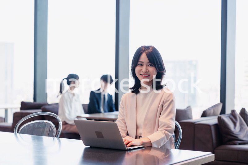シェアオフィスでノートパソコンを使うビジネスウーマン