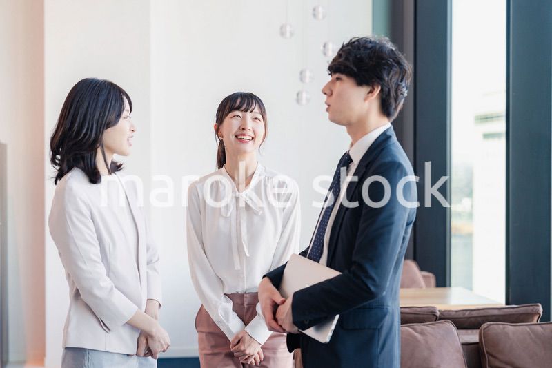 オフィスで仲良く話す若いビジネスパーソン