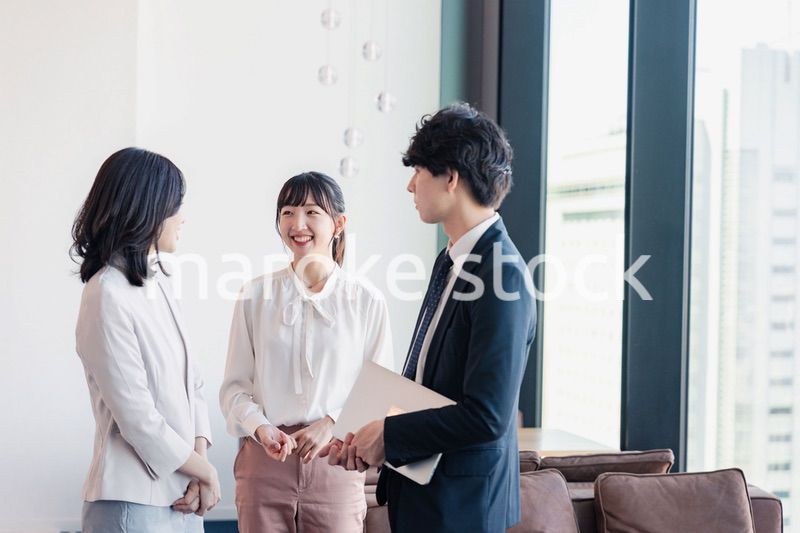 オフィスで仲良く話す若いビジネスパーソン