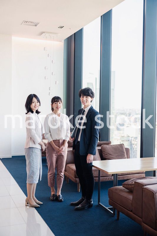 オフィスで仲良く話す若いビジネスパーソン