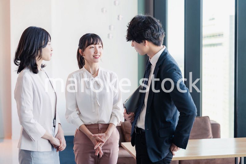 オフィスで仲良く話す若いビジネスパーソン