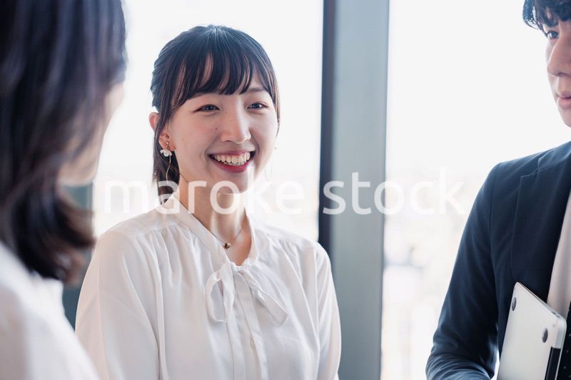 オフィスで仲良く話す若いビジネスパーソン