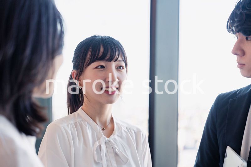 オフィスで仲良く話す若いビジネスパーソン