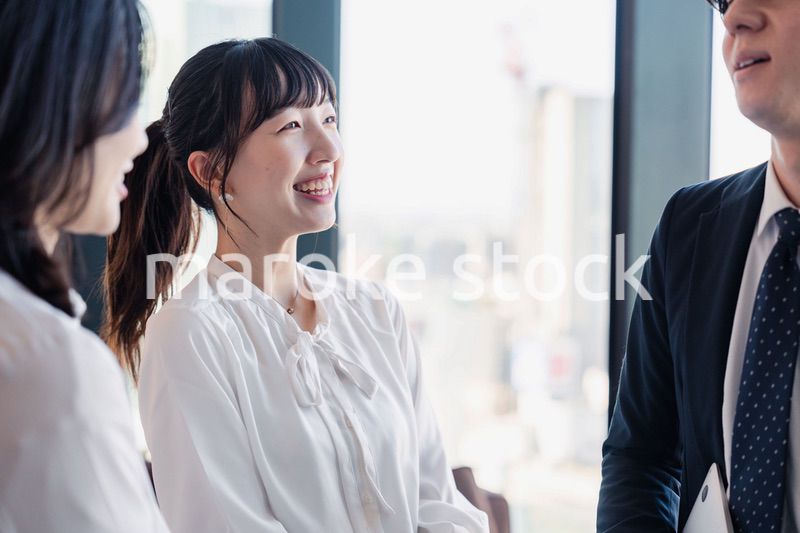 オフィスで仲良く話す若いビジネスパーソン