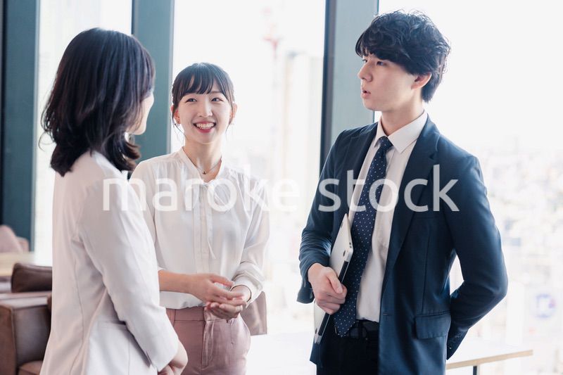 オフィスで仲良く話す若いビジネスパーソン