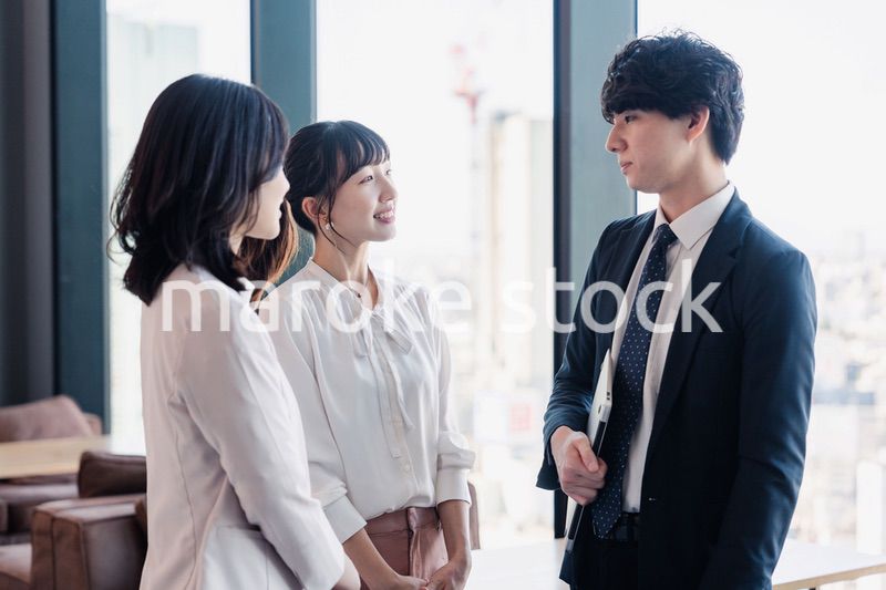オフィスで仲良く話す若いビジネスパーソン