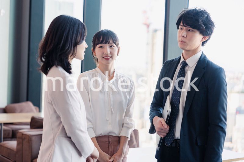 オフィスで仲良く話す若いビジネスパーソン