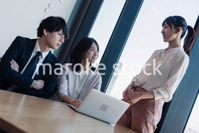 オフィスで仲良く話す若いビジネスパーソン