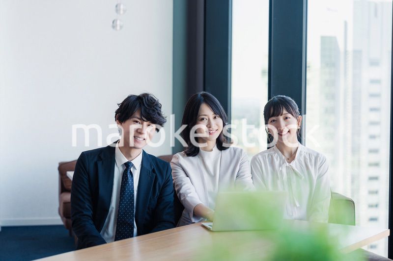 オフィスで仲良く話す若いビジネスパーソン