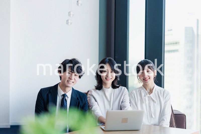 オフィスで仲良く話す若いビジネスパーソン