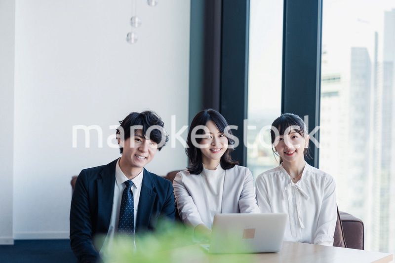 オフィスで仲良く話す若いビジネスパーソン