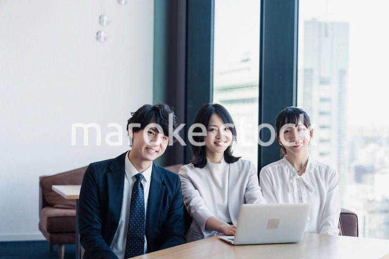 オフィスで仲良く話す若いビジネスパーソン